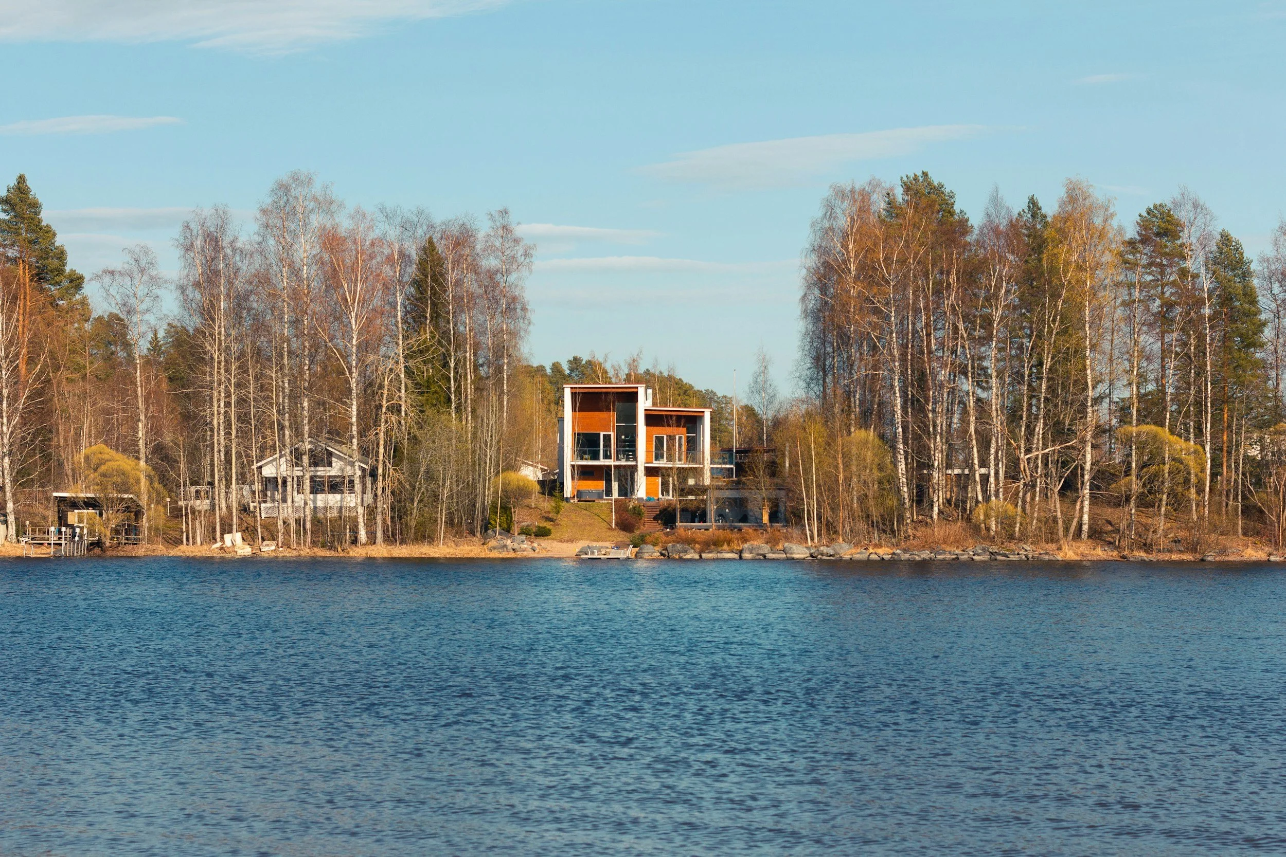 Modern house on the water with trees in the background