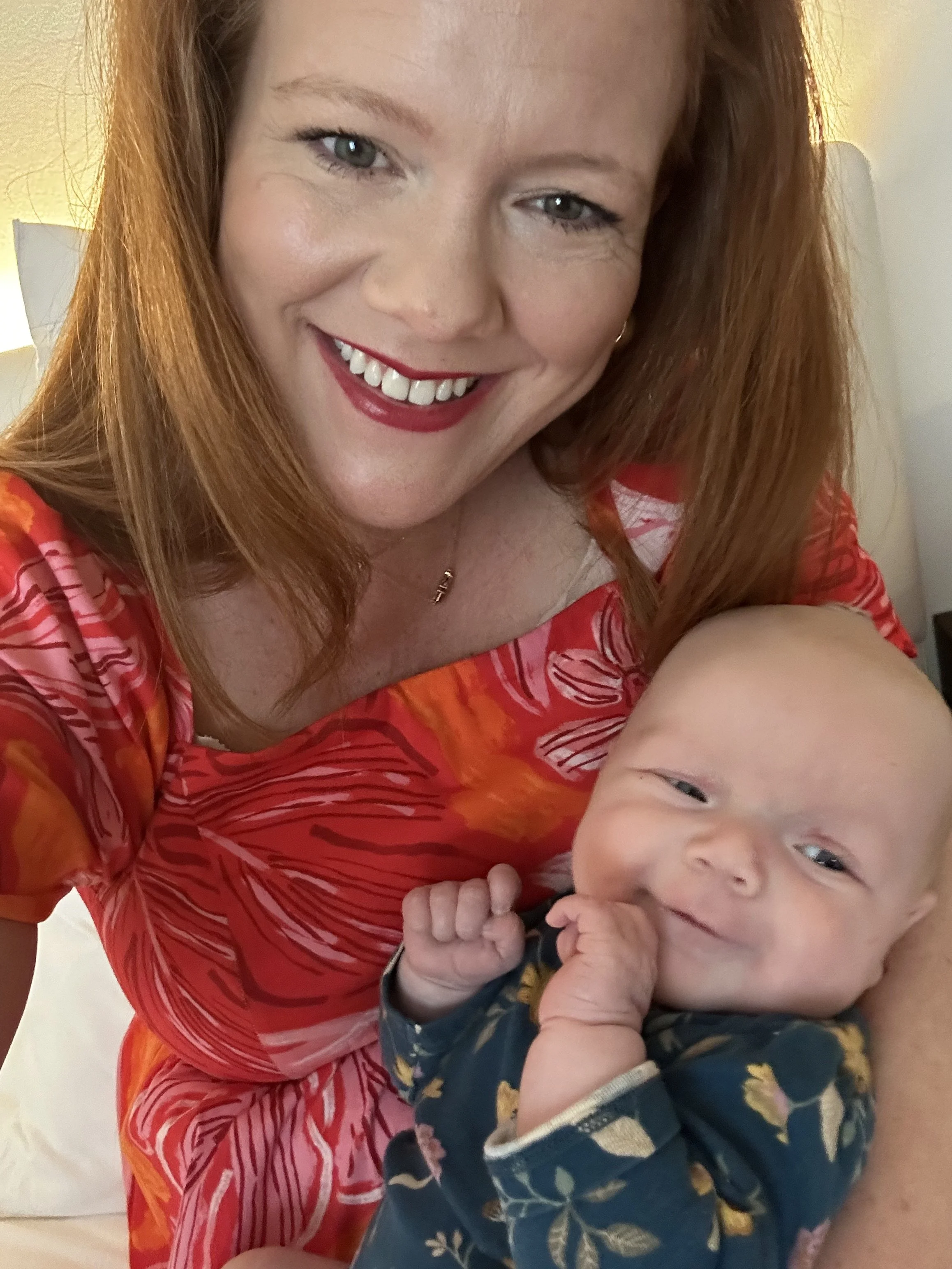 Abigail smiling and holding baby Rosie in a Fort Worth hotel room the morning after Rosie first slept through the night