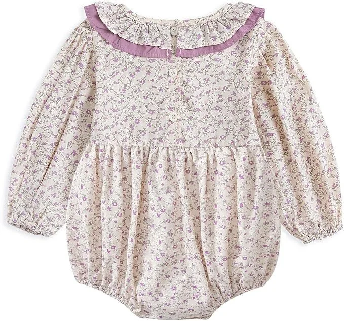 Cream baby girl bubble romper with a purple floral print and ruffled lilac-trimmed collar.