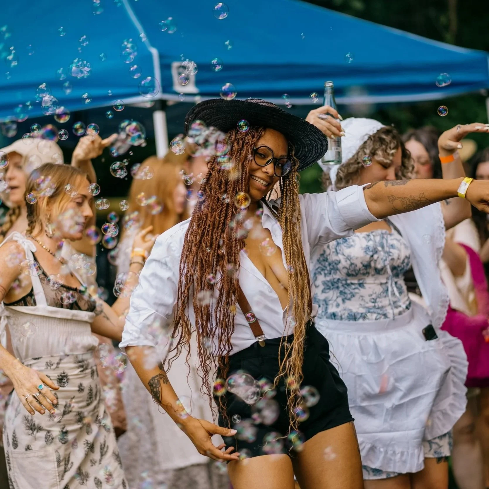 Group of woman laughing and dancing at an outdoor music and art festival in western north carolina