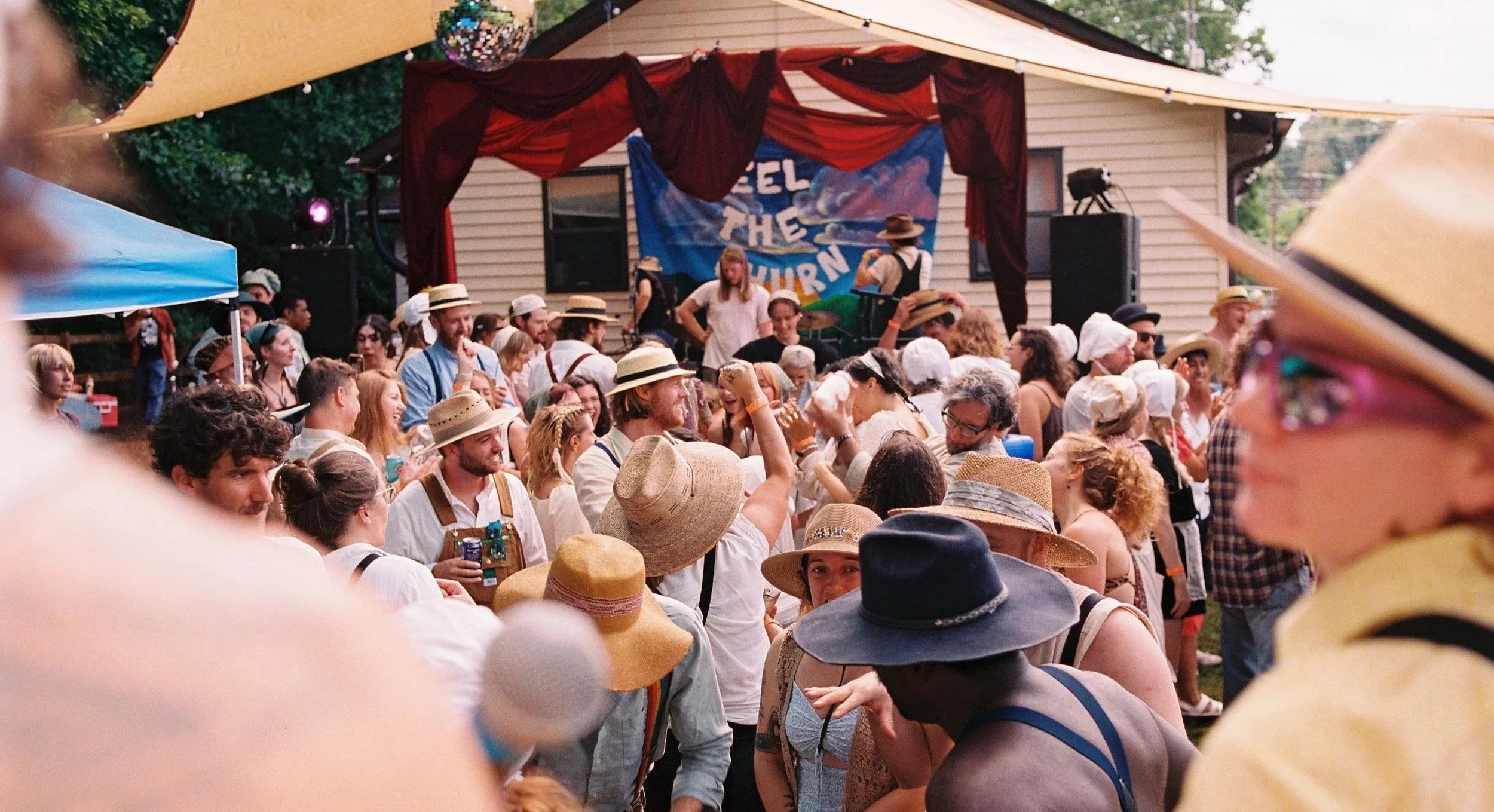 Crowd dancing at Churning Man music and arts camping festival near Asheville, North Carolina at sunset