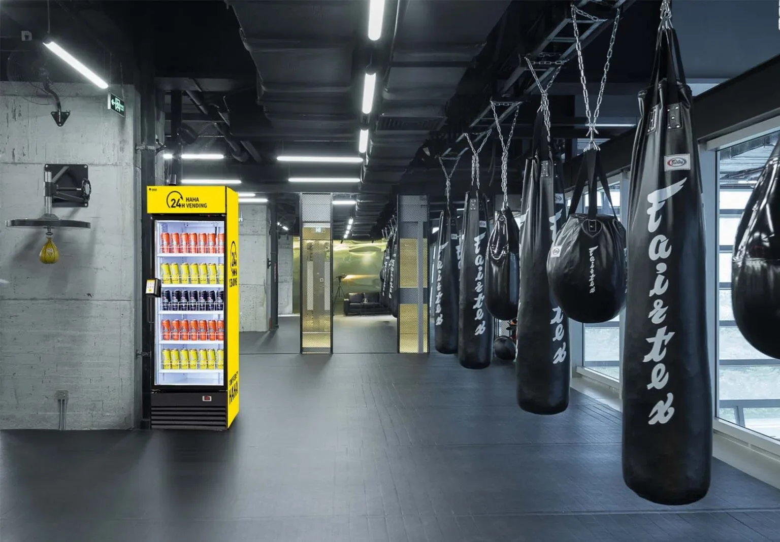 Empty boxing gym with hanging punching bags and vending machine