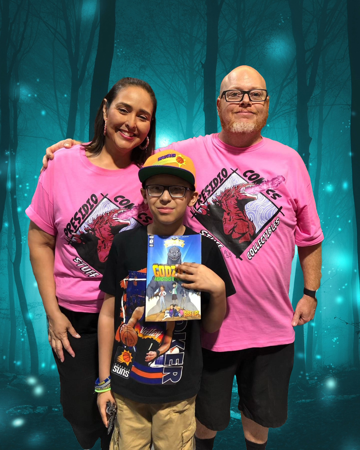 Family group photo with woman, man, and boy in front of a digitally added woodland background. The woman and man are wearing pink T-shirts with a graphic logo. The boy is holding a graphic novel, and the boy has a basketball-themed T-shirt, a cap, and glasses.