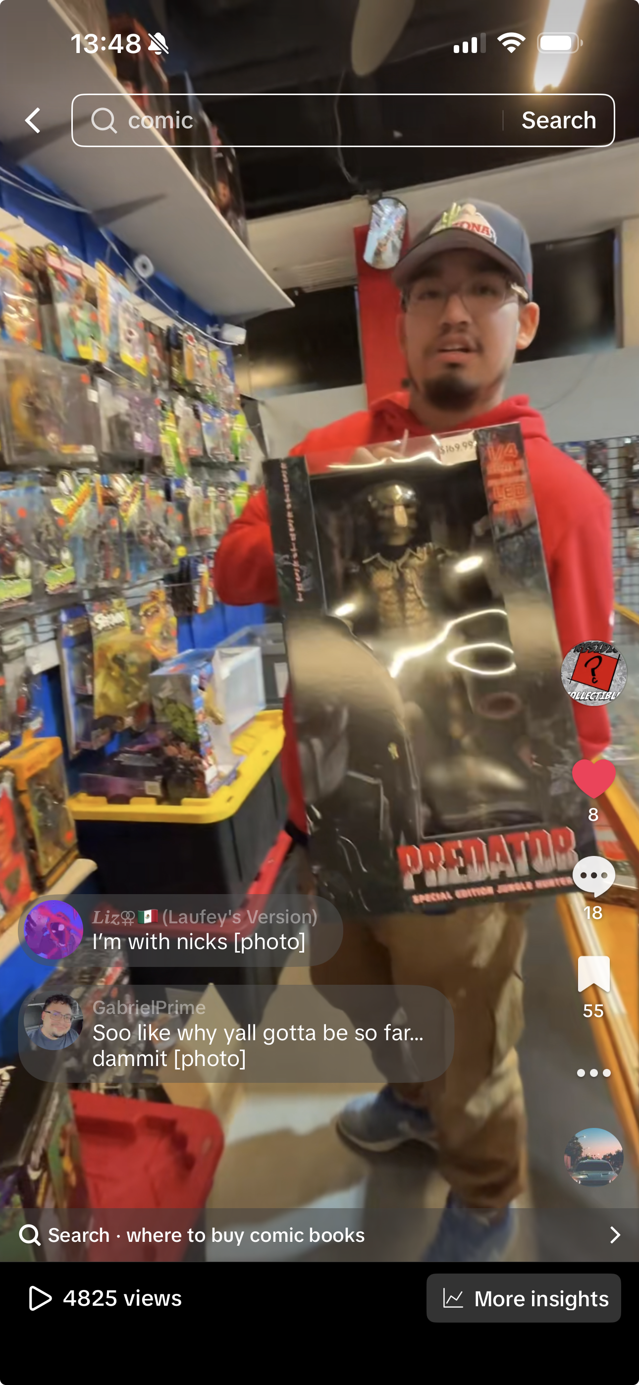 A man in a gray cap and red hoodie holding a 'Predator' action figure in its packaging at a comic book store or toy shop, with shelves of toys and collectibles in the background.