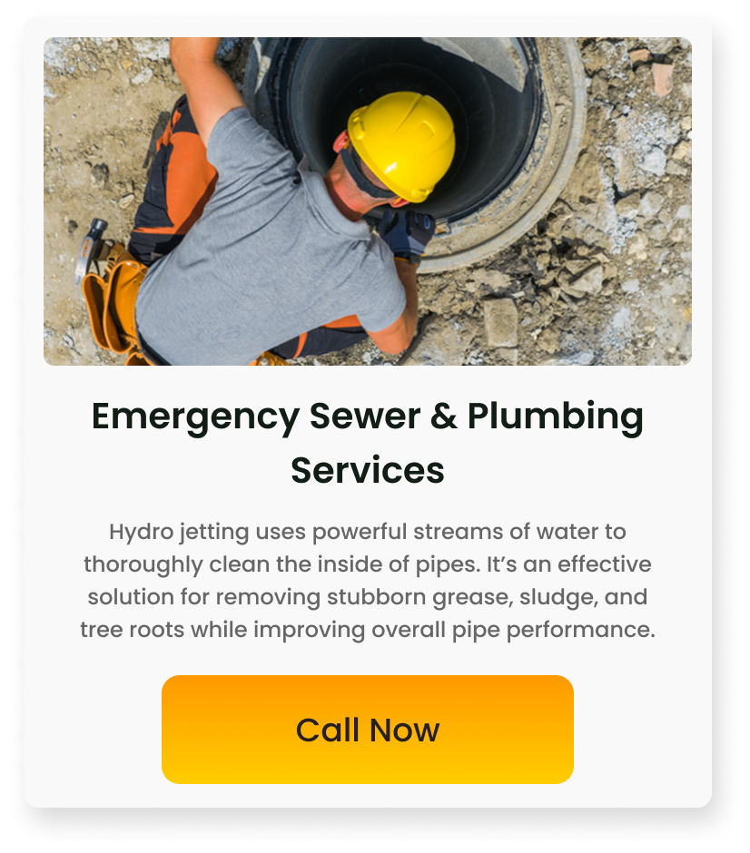 A worker in a gray shirt and yellow safety helmet inspecting a sewer pipe at a construction site.