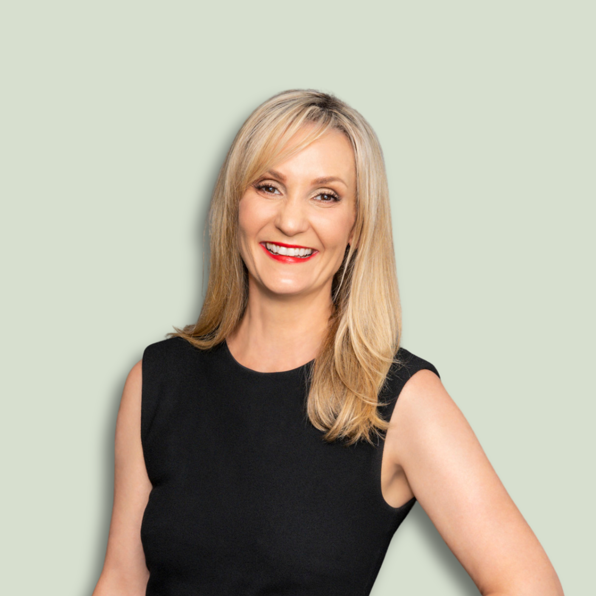 Portrait of a smiling woman with blonde hair, wearing a sleeveless black top, against a light green background.