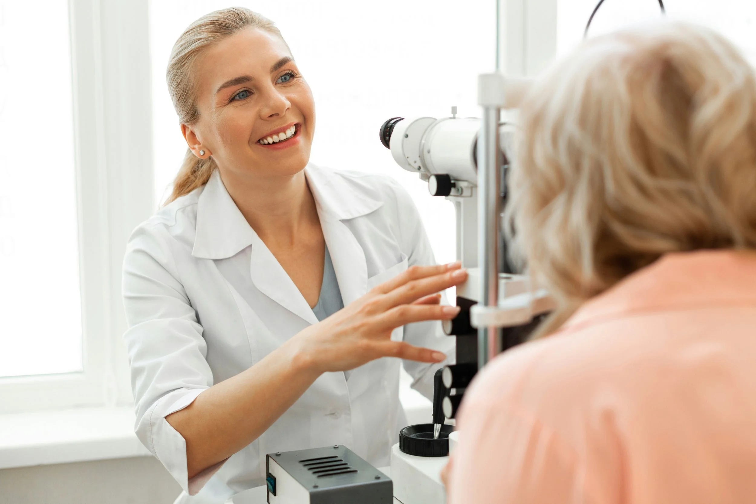 Optometrist conducting eye examination on an elderly woman using a slit lamp.