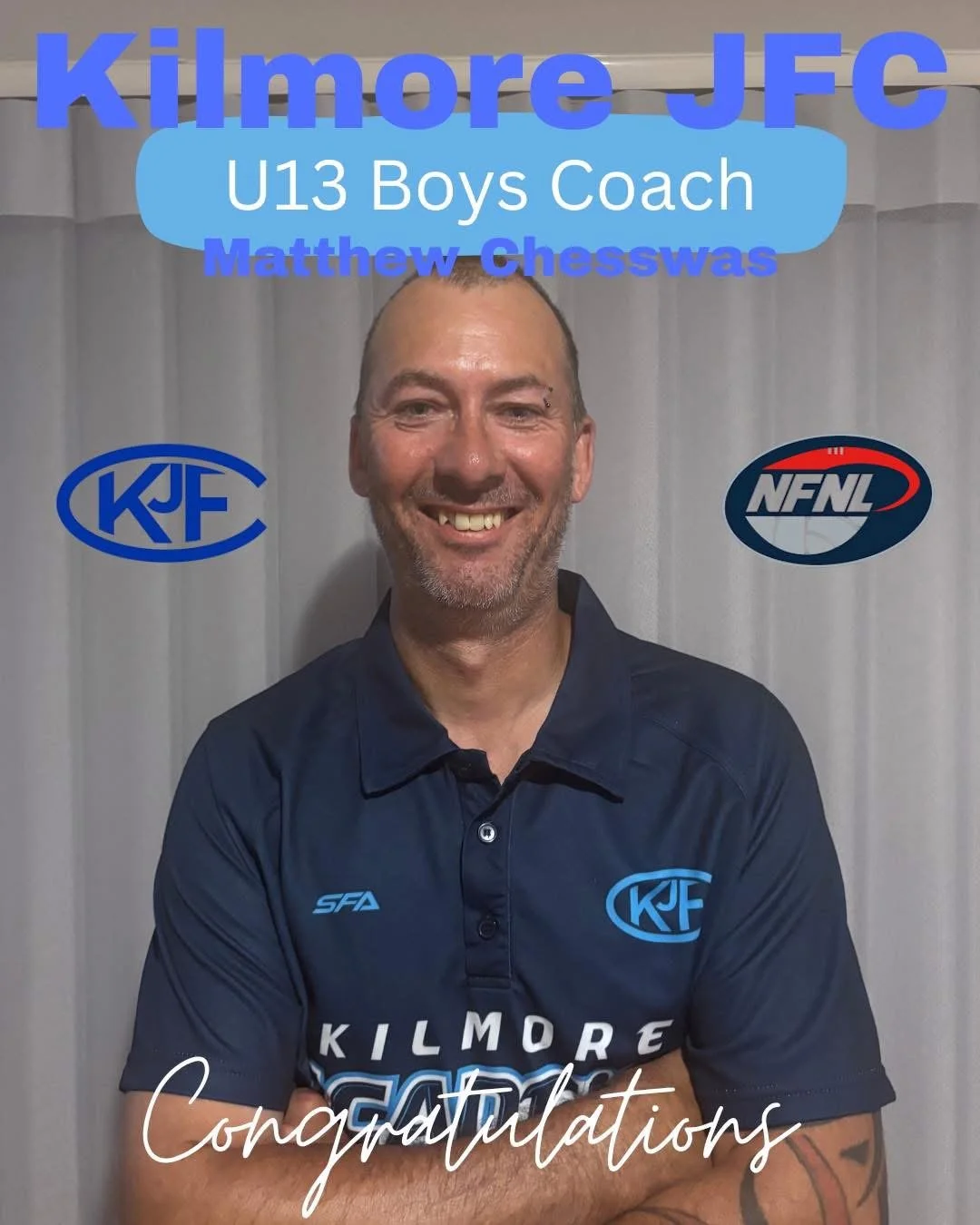 A man smiling in a blue Kilmore JFC coach shirt with text and logos on it, standing in front of a gray curtain background. Text on the image indicates he is Matthew Chesswas, the U13 Boys Coach, with congratulatory message.