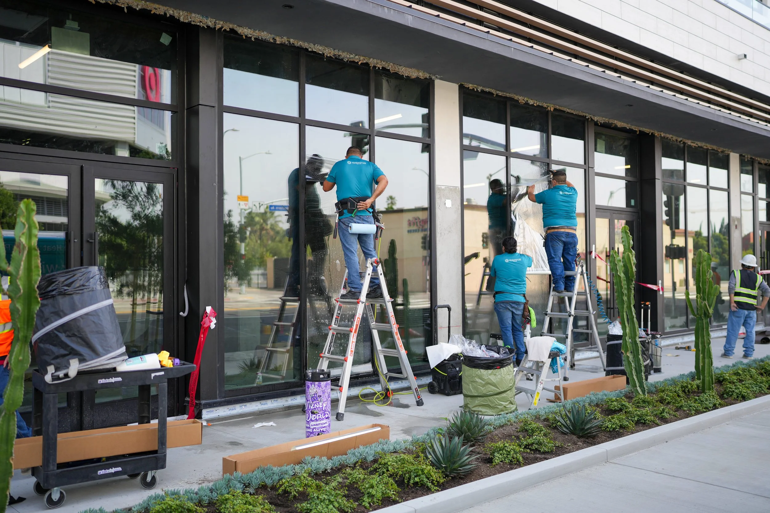Retail storefront windows protected with anti-graffiti film to reduce damage from tagging and vandalism