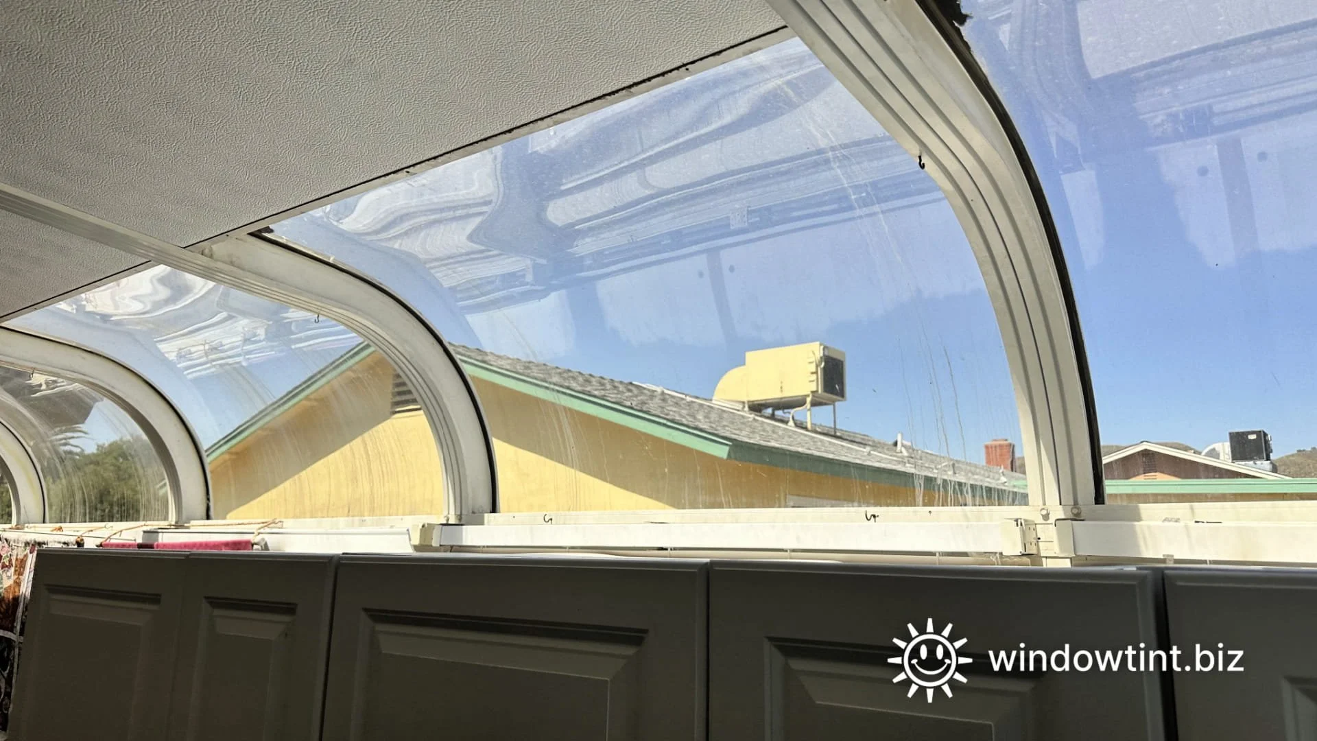 Curved sunroom windows with window film installed to reduce heat and glare in a Southern California home.