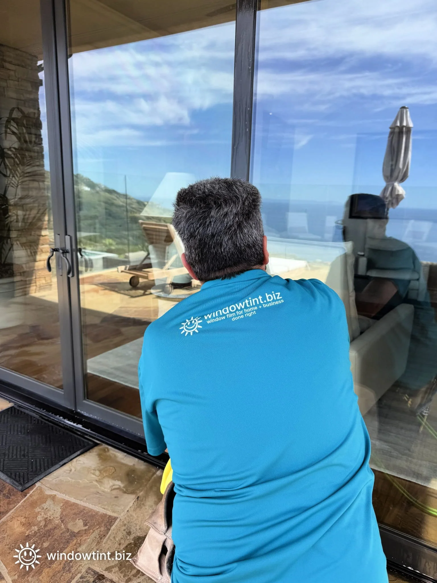 Professional technician installing residential security window film on sliding glass doors in Dana Point CA, enhancing home protection, safety, and break-in resistance