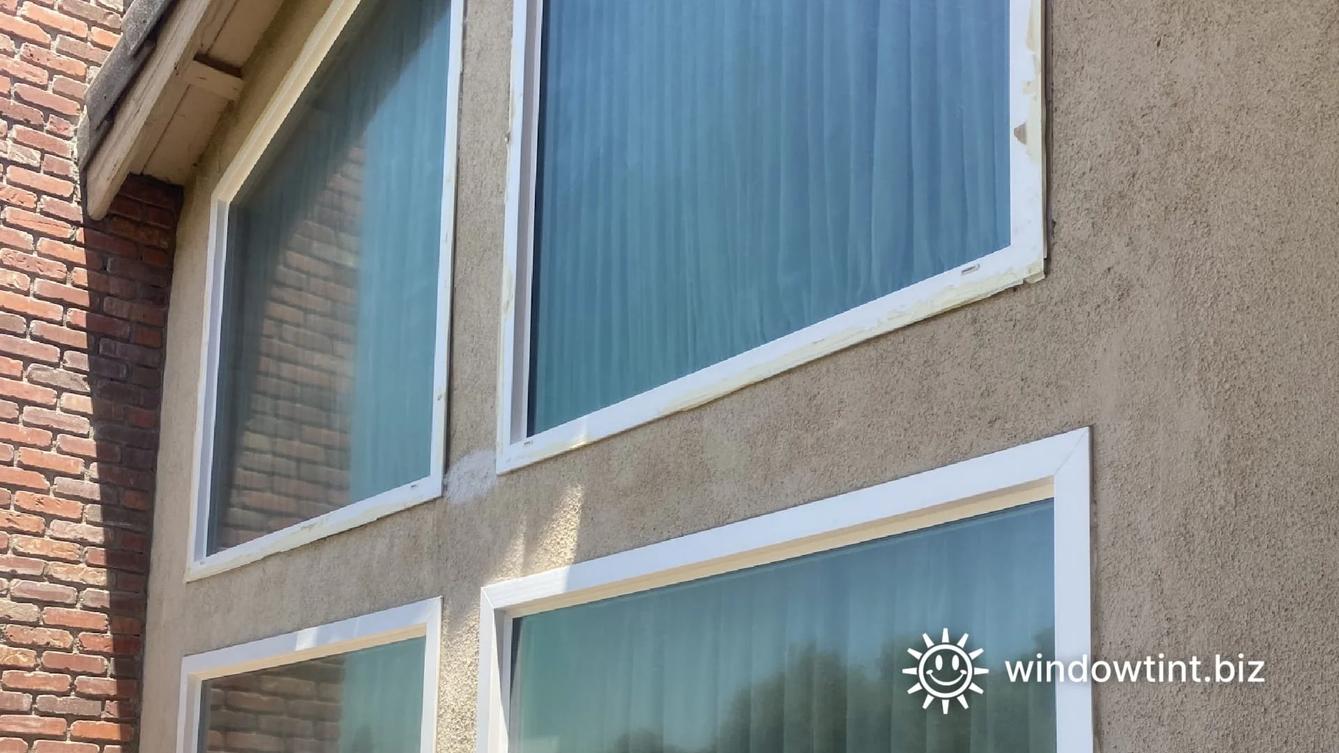 Upper floor windows reflecting sunlight and melting artificial turf at a Temecula CA home