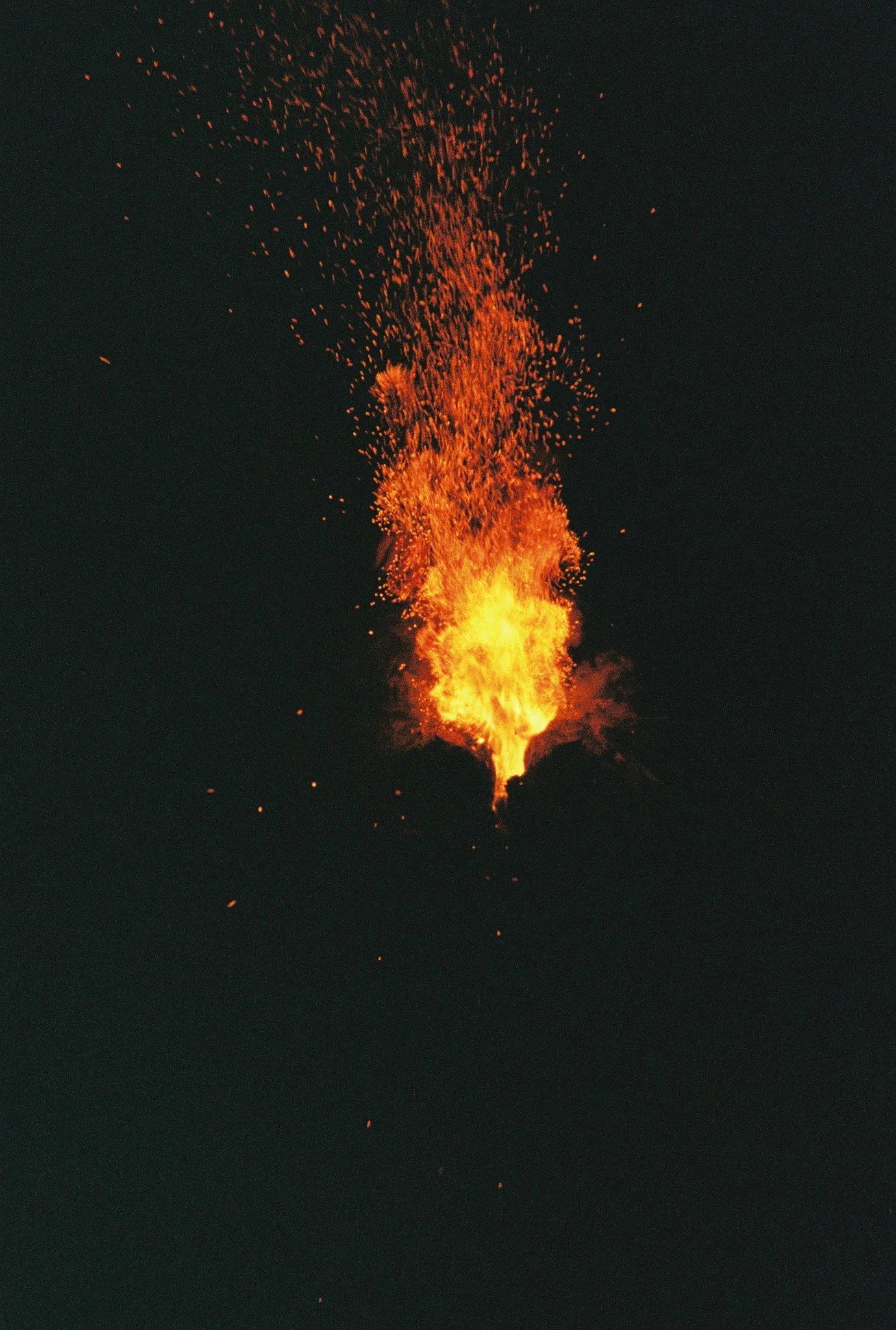 Fiery explosion with bright orange flames and sparks against a dark background.