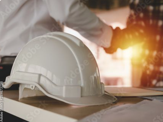 Rakennustyömaan kypärä pöydällä työpöydässä.