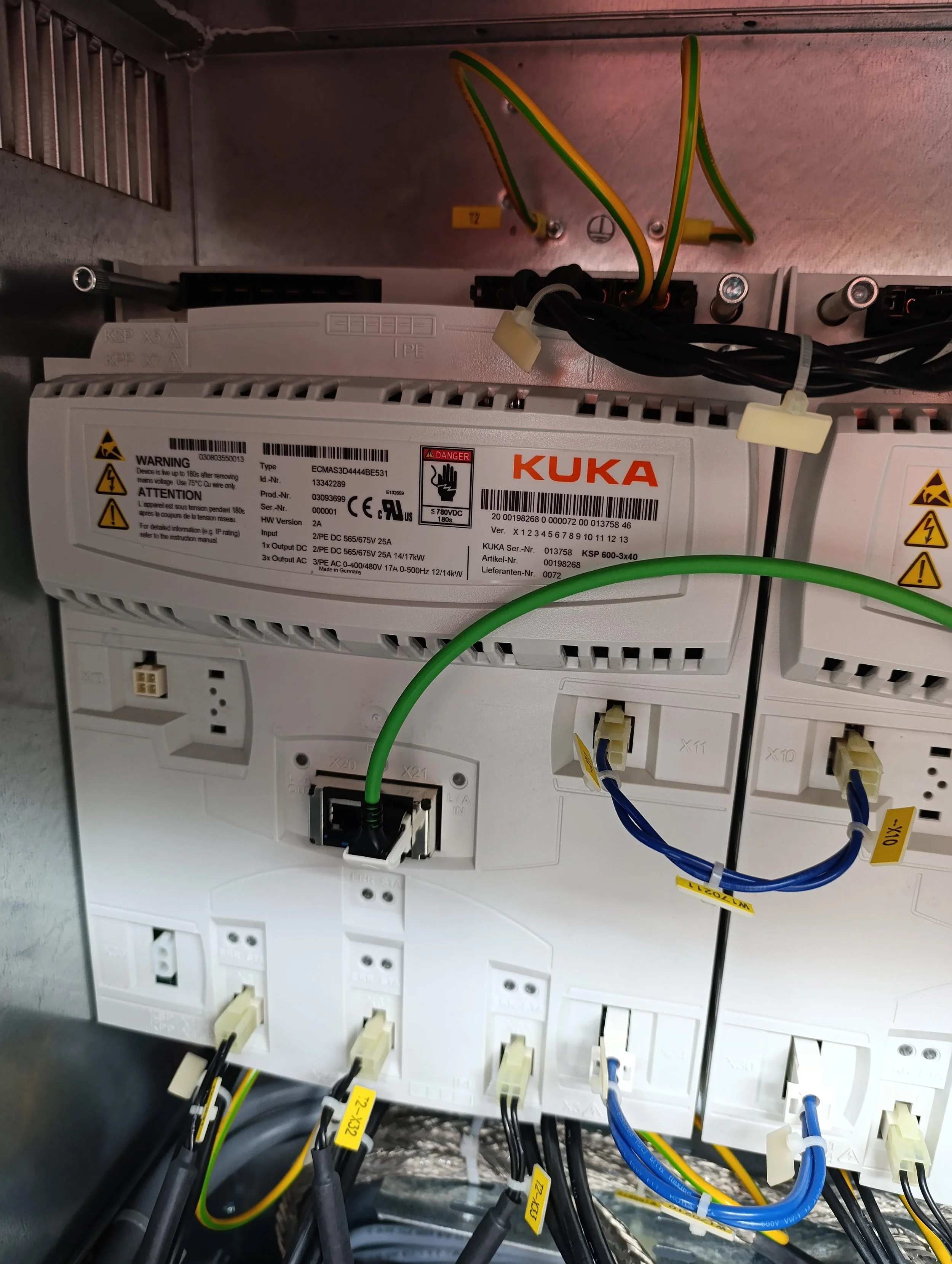 Elektrik devre panosu içinde çeşitli renklerde kablolar ve bağlantılar, güç kaynakları ve sigortalara ulaşmak için tasarlanmış düzenek.