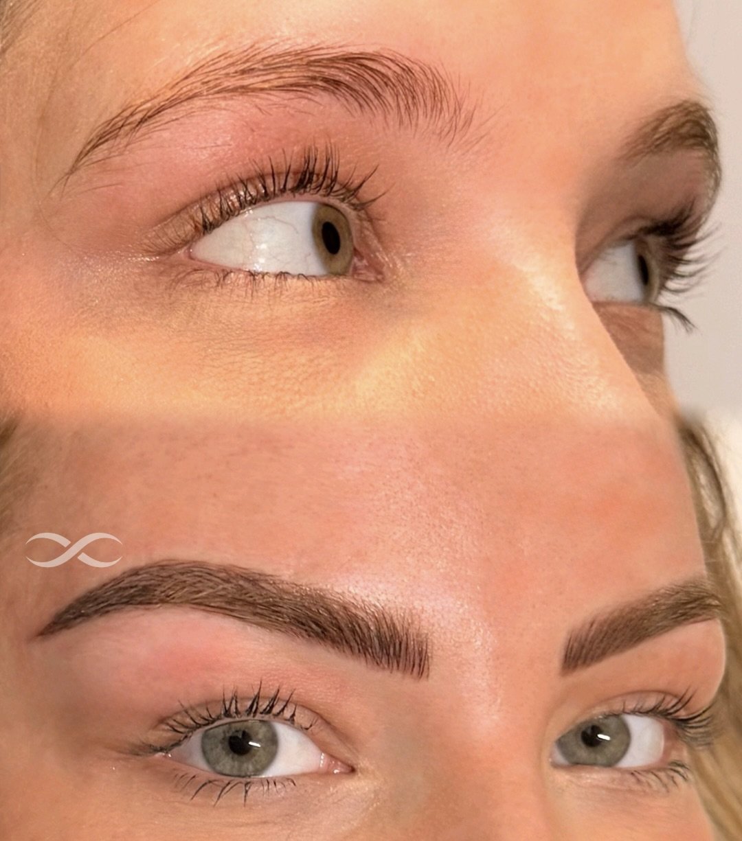 Close-up of a woman's eyes and eyebrows, showing before and after makeup or eyebrow enhancement, with the top part of the image depicting natural eyebrows and the bottom part showing filled-in, shaped, and darker eyebrows.