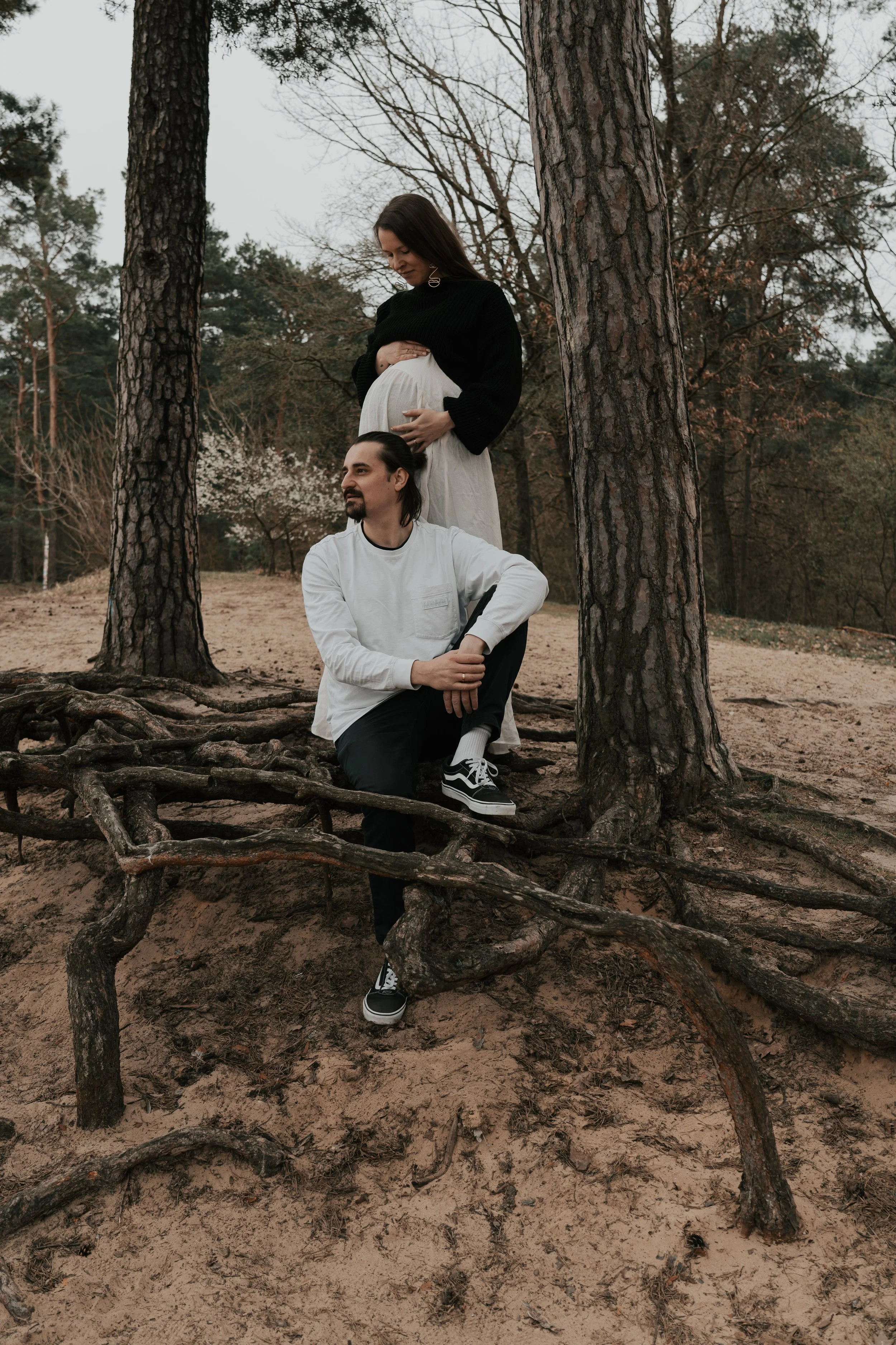 Authentische Familienfotografie in Berlin Köpenick & Brandenburg – Familie posiert ungestellt an den großen Baumwurzeln in der Natur.
