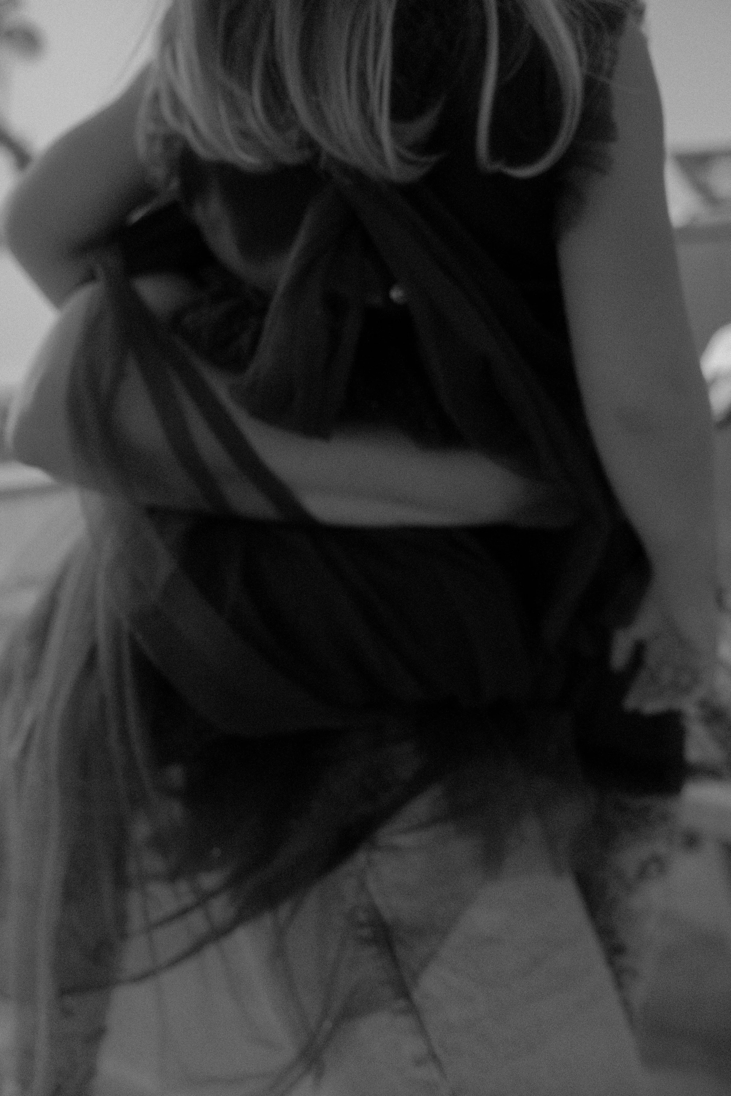 Schwarz-Weiß-Foto eines Mädchens im Bündchen-Kleid, das das Bild in einer ungewöhnlichen Haltung hält.