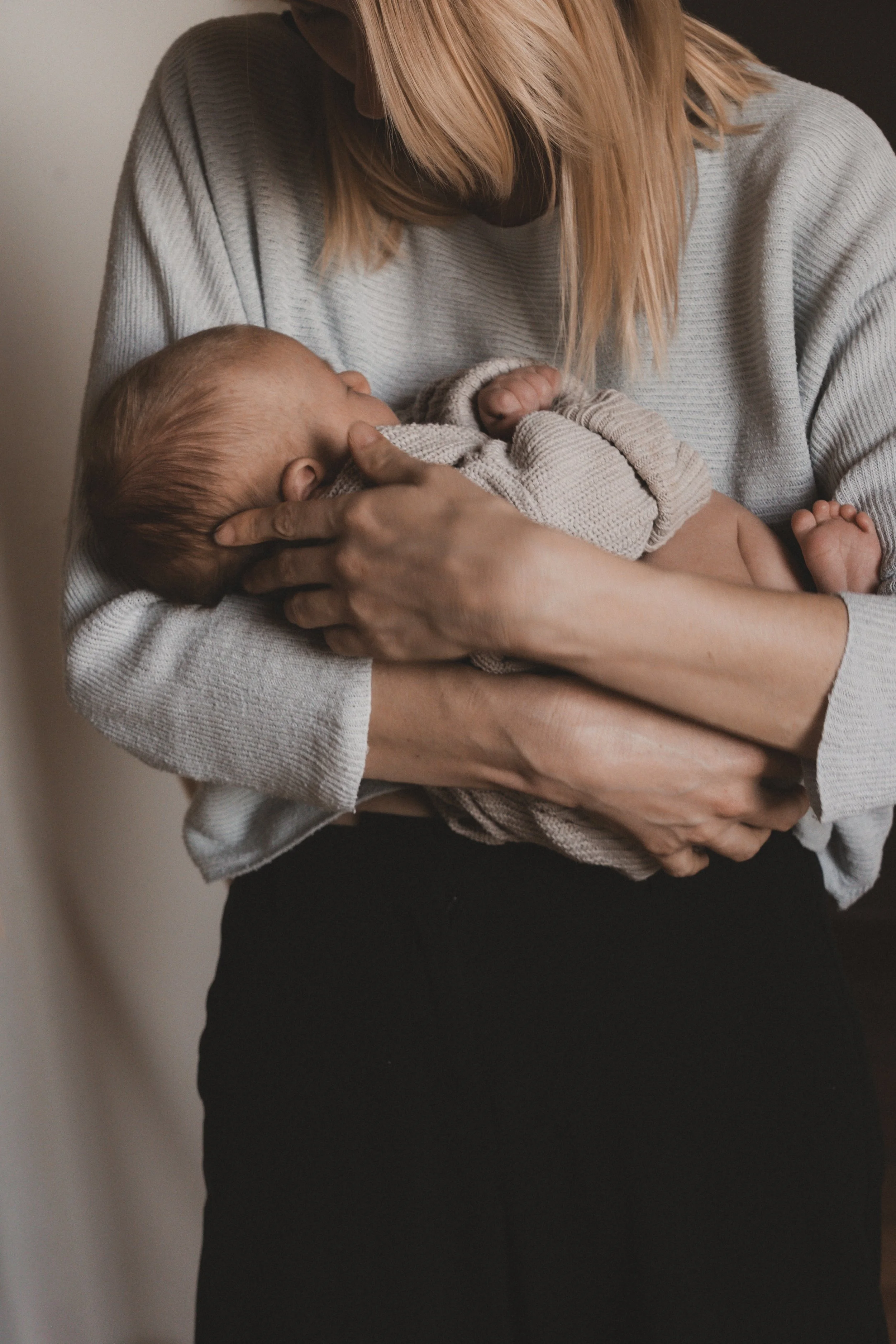 Eine Frau hält ein Baby im Arm und saugt es.