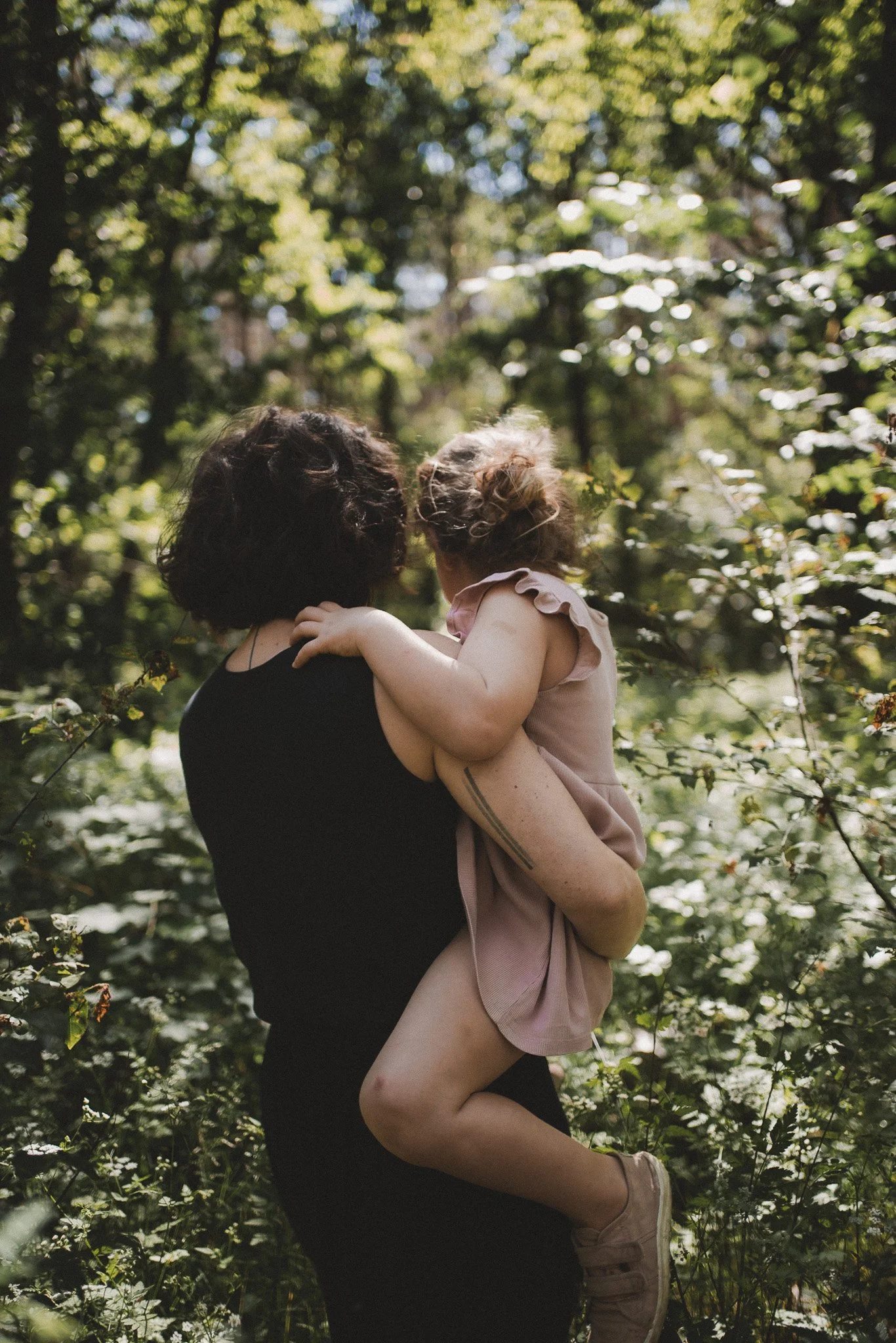 Emotionale Motherhood- und Familienfotografie – Mutter hält ihr kleines Mädchen innig im Arm inmitten der Natur bei Berlin.