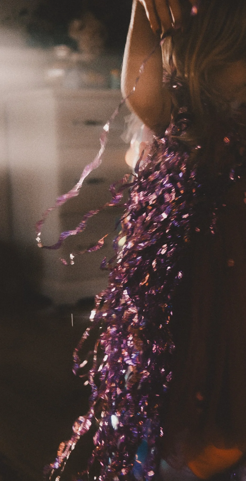 Bunte metallic schimmernde Girlande auf einer dunklen Oberfläche