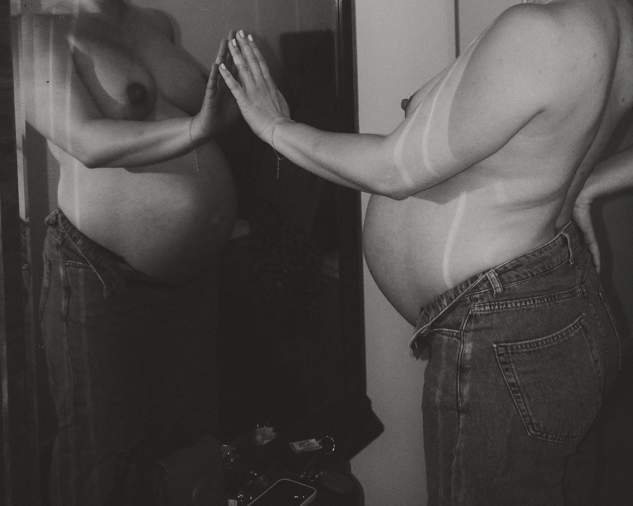 Eine Frau betrachtet und berührt ihr Spiegelbild – ein stilles, künstlerisches Porträt über Körper, Veränderung und Nähe.