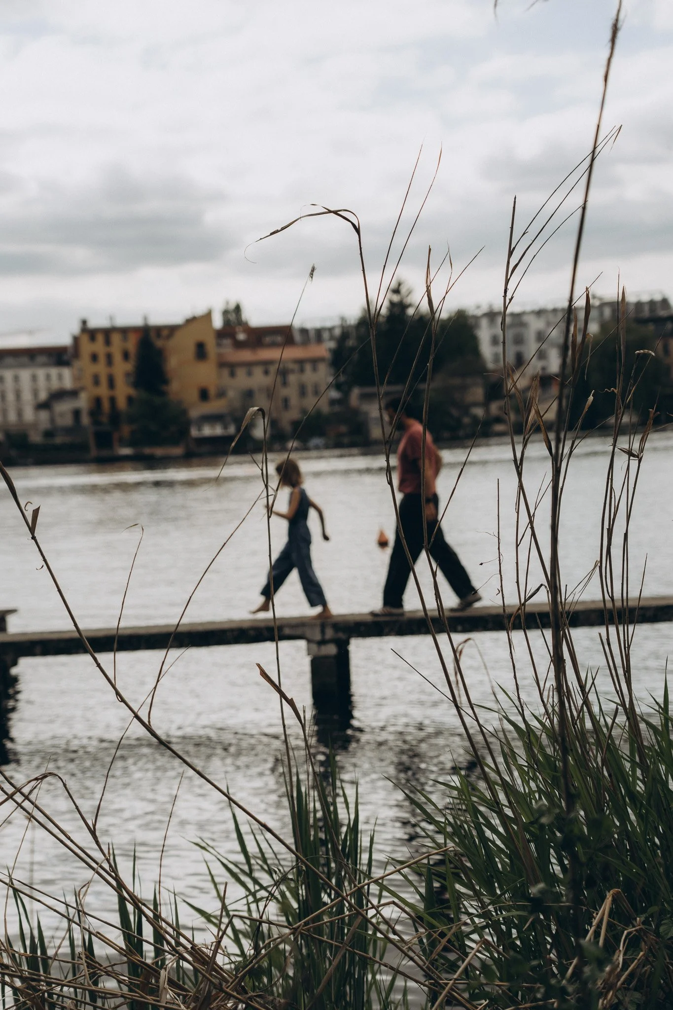 Authentisches Lifestyle- und Familienshooting Berlin Spree– zwei Menschen spazieren ungestellt über steg
