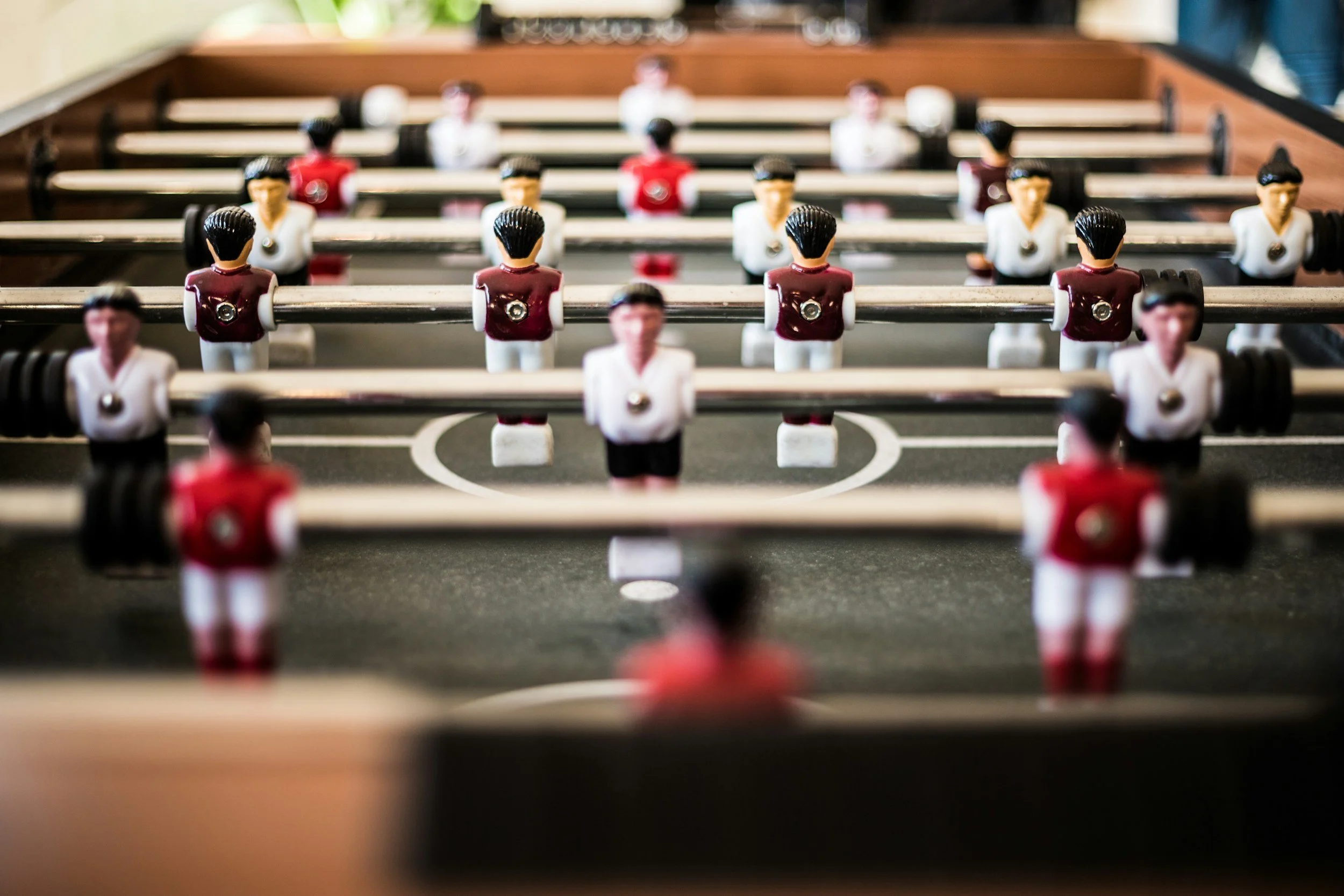 Nahaufnahme eines Tischkickerspiels mit Figuren in Rot und Weiß.