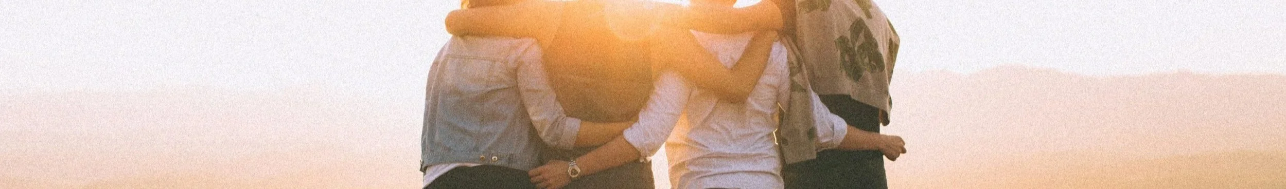 Grupp Menschen auf einem Sonnenuntergang.