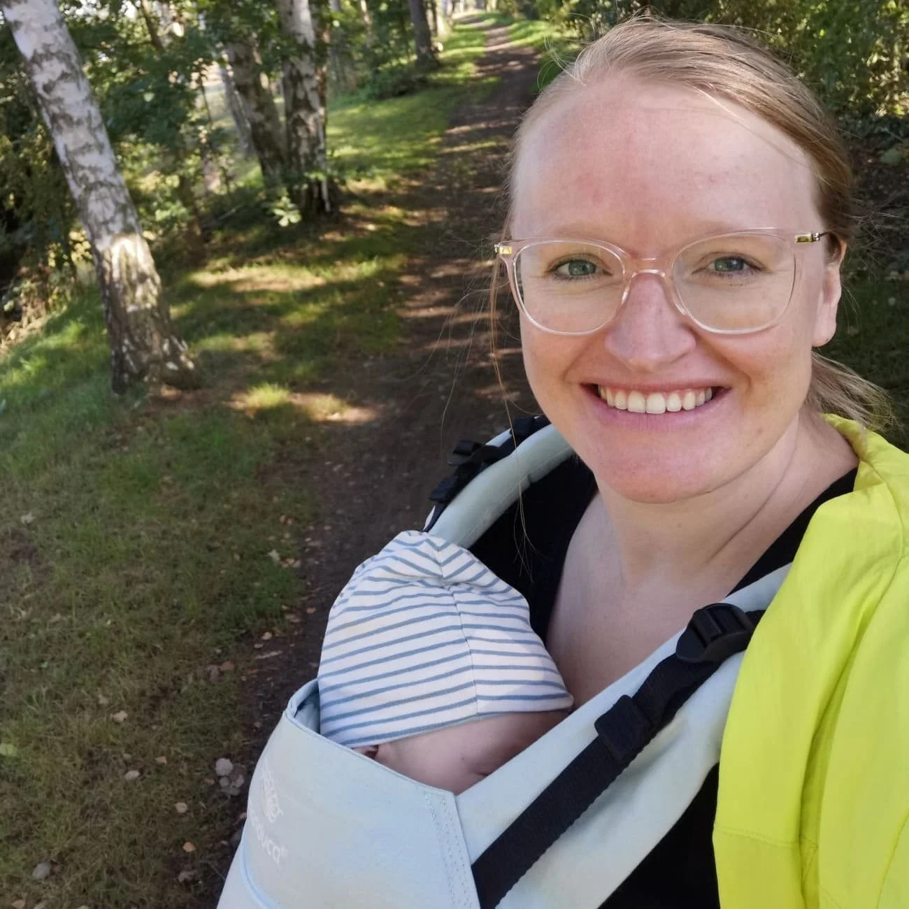 Mutter trägt ihr Baby im Tragetuch im Freien