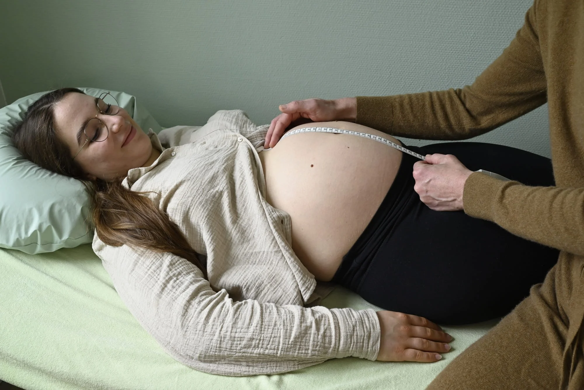 Bauchumfang einer Schwangeren wird mit Maßband gemessen