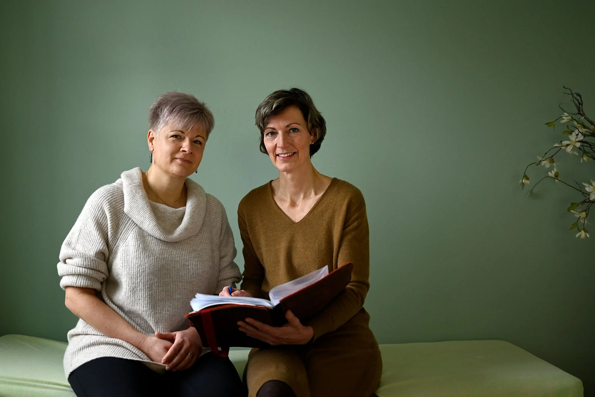 Die Hebammen Mandy Wendrich und Doreen Henoch sitzen gemeinsam mit Unterlagen im Beratungsraum