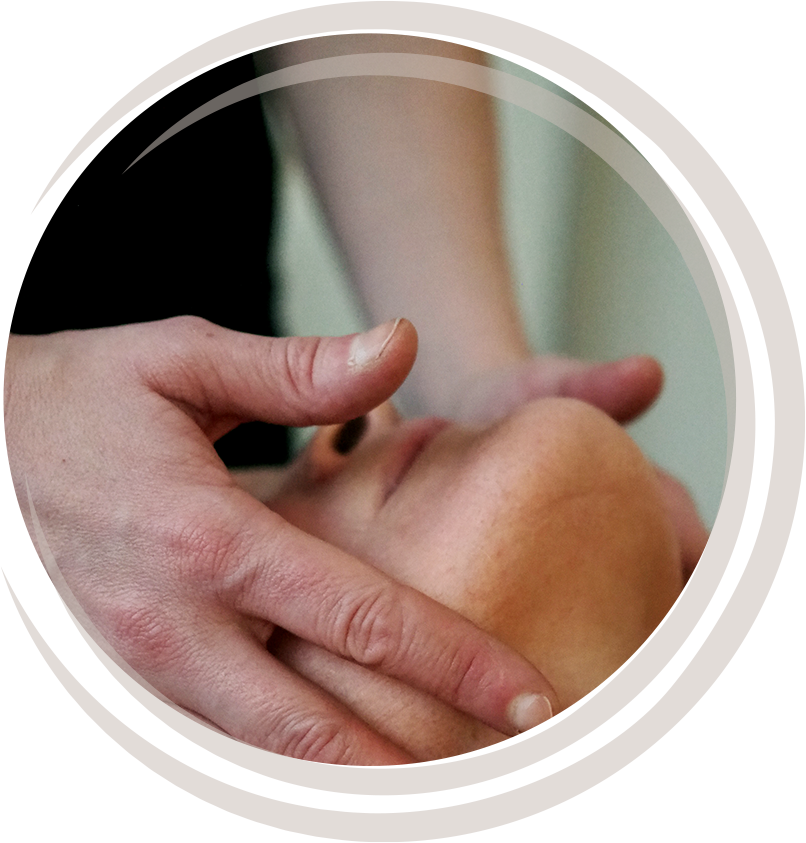 Henkilö saa hierontaa kasvoihin, lähikuva kädest ja kasvojen ihosta.