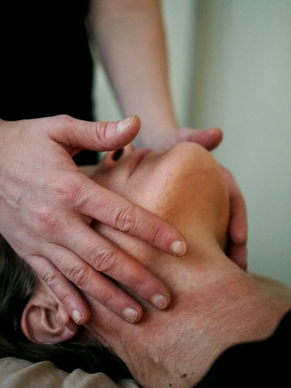 Henkilö saa hierontaa tai hoitoa kaulan alueelle.