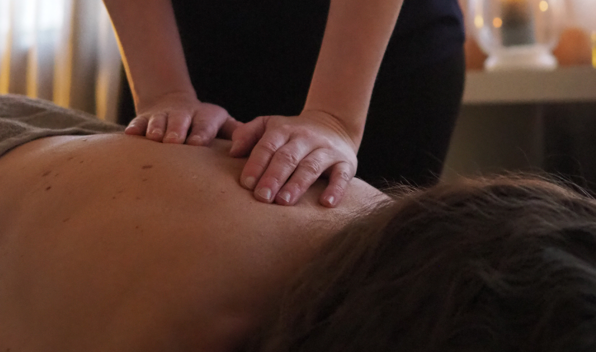 Hieroittelaja annetaan selvästi jonkinlaista hierontaa tai hoitoa selälle.