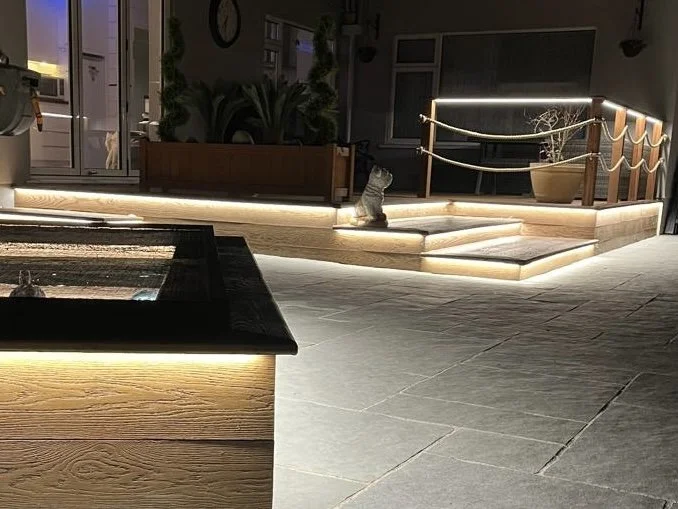 Nighttime view of a Millboard deck with illuminated steps, and modern lighting accents.