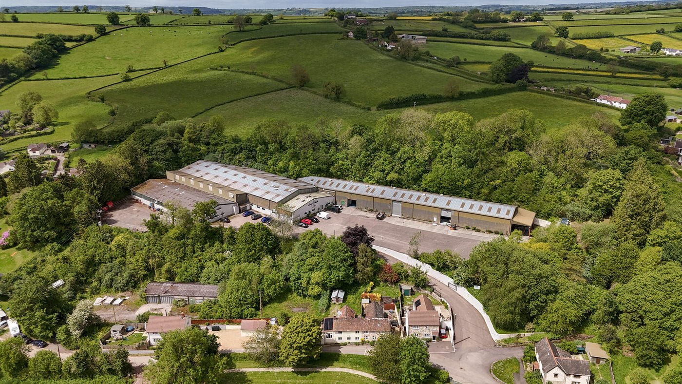 Factory setting taken by a drone from above for a unique perspective. An industrial estate surrounded by green fields and amongst a small village in Chard.