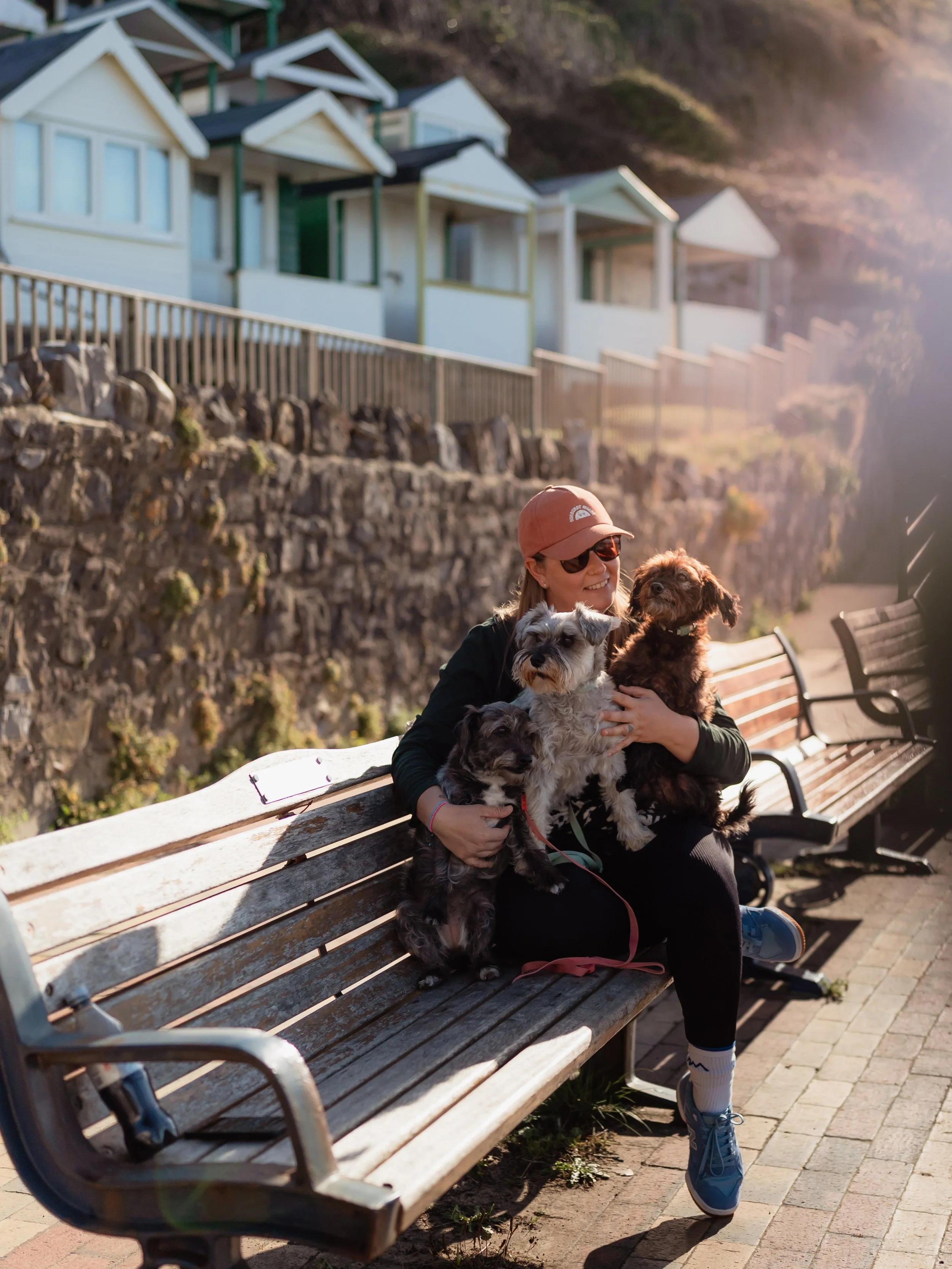 Photograph of photographer Amy Reed at Rotherslade beach in a hat with her rescue dogs.