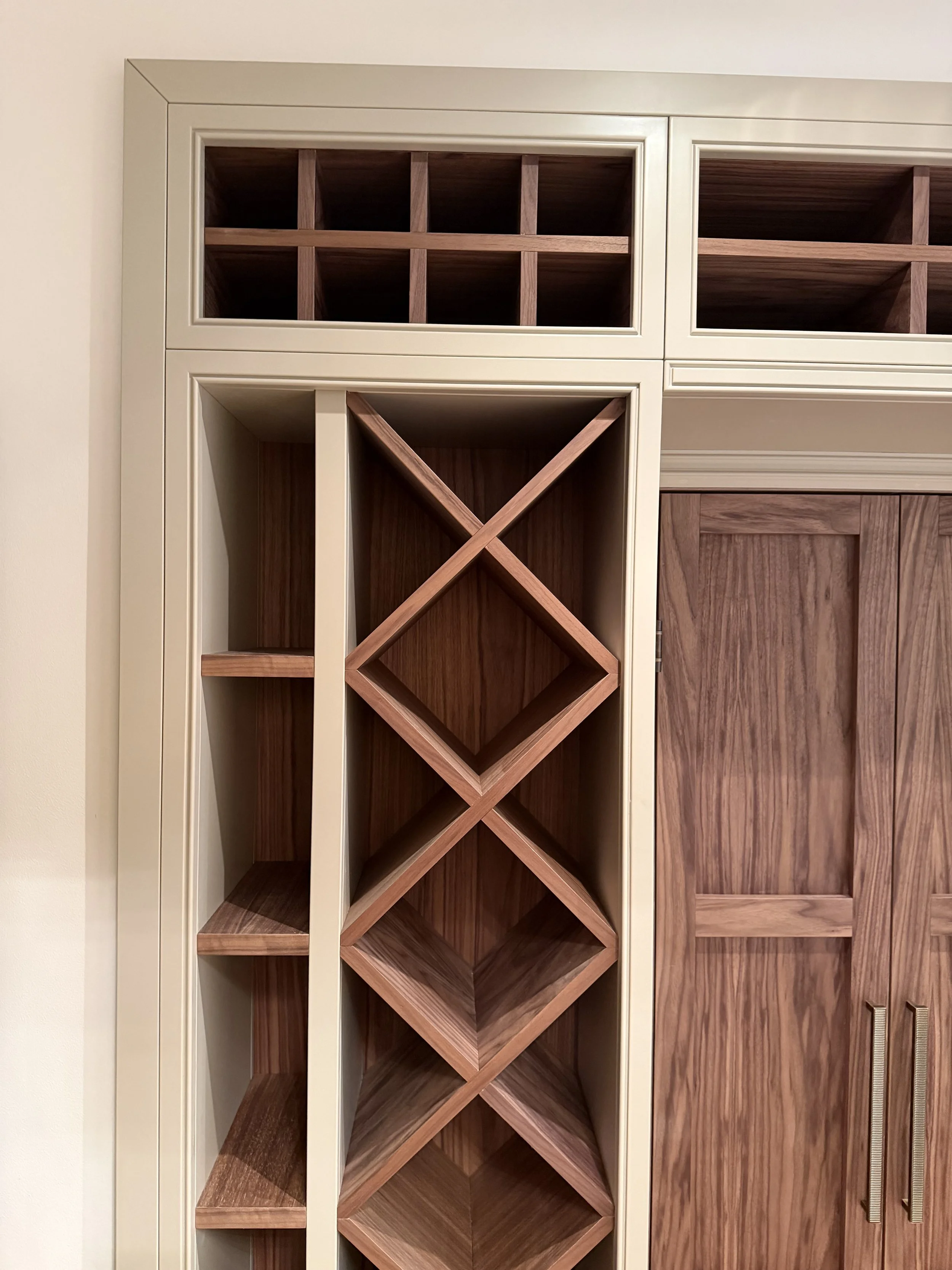 Wooden wine rack and cabinet with sliding doors in a room.