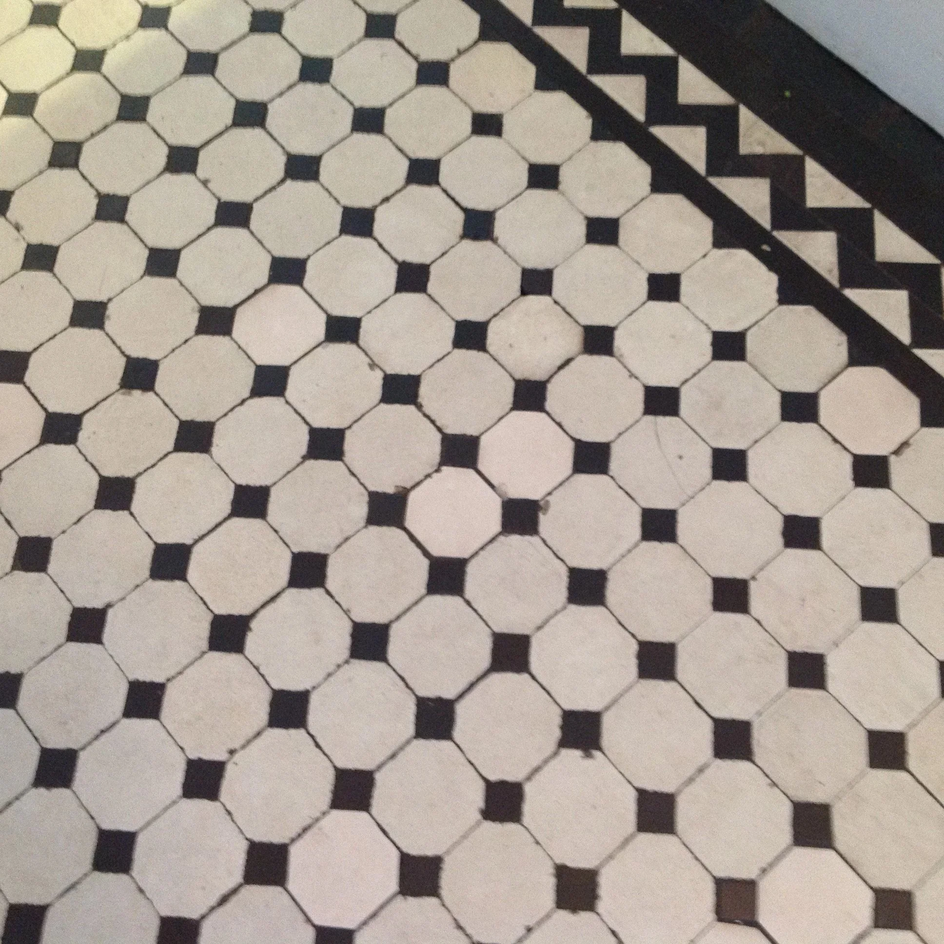 Black and white geometric patterned tile flooring with octagon and square shapes.