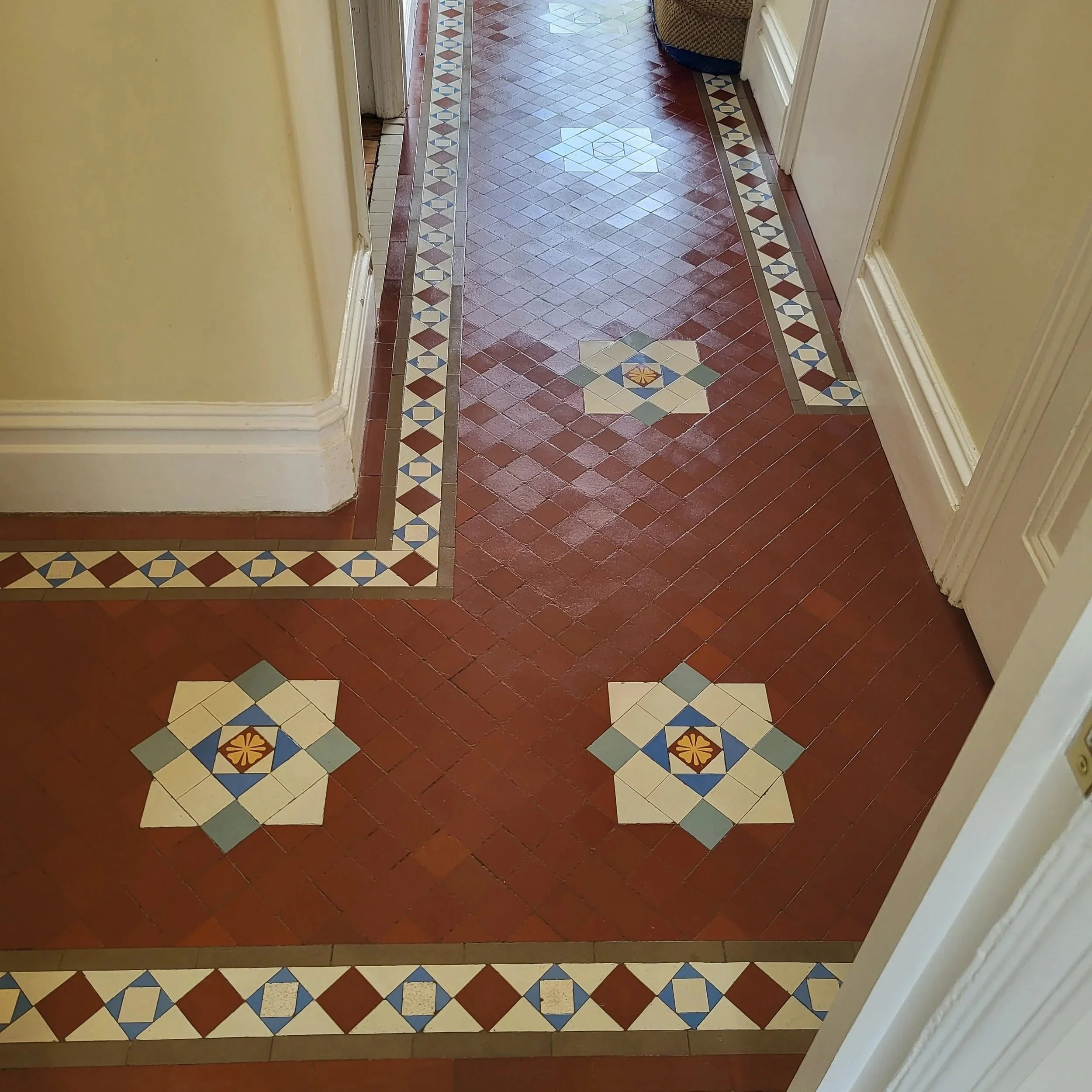 Decorative tile floor with red, cream, blue, and yellow patterns in a hallway.