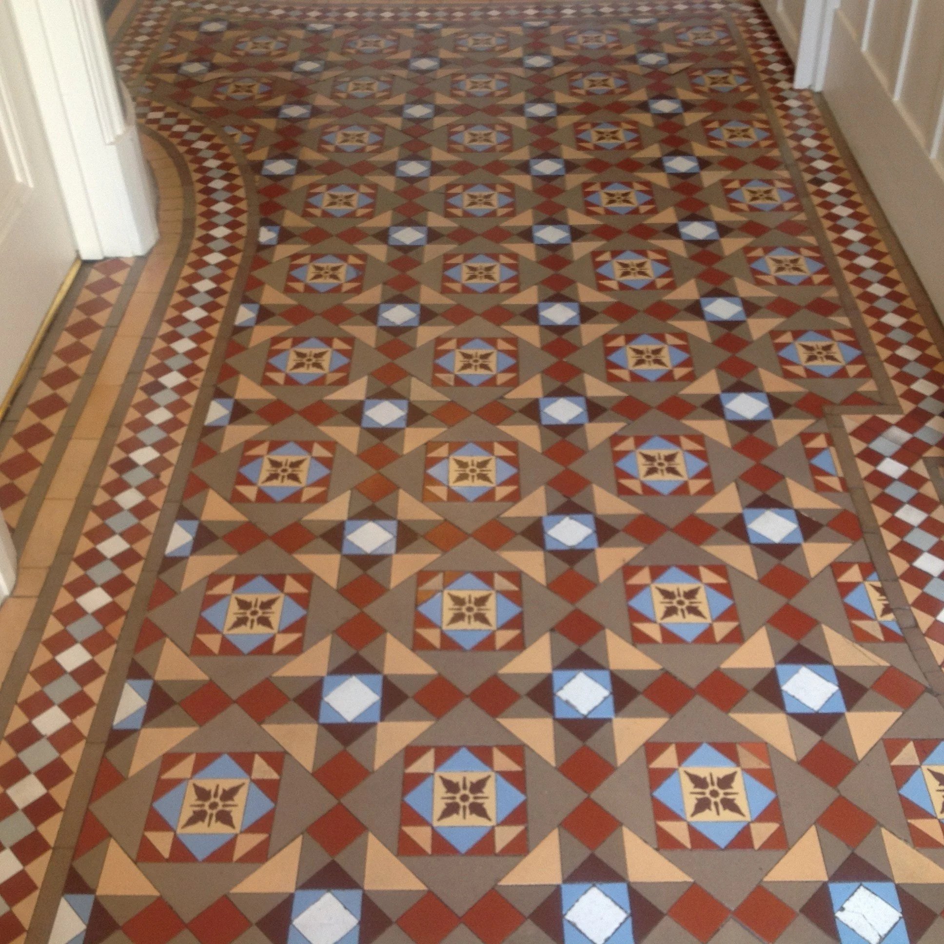 Ornate patterned tile floor with geometric shapes and star motifs, bordered by a smaller checkered pattern.