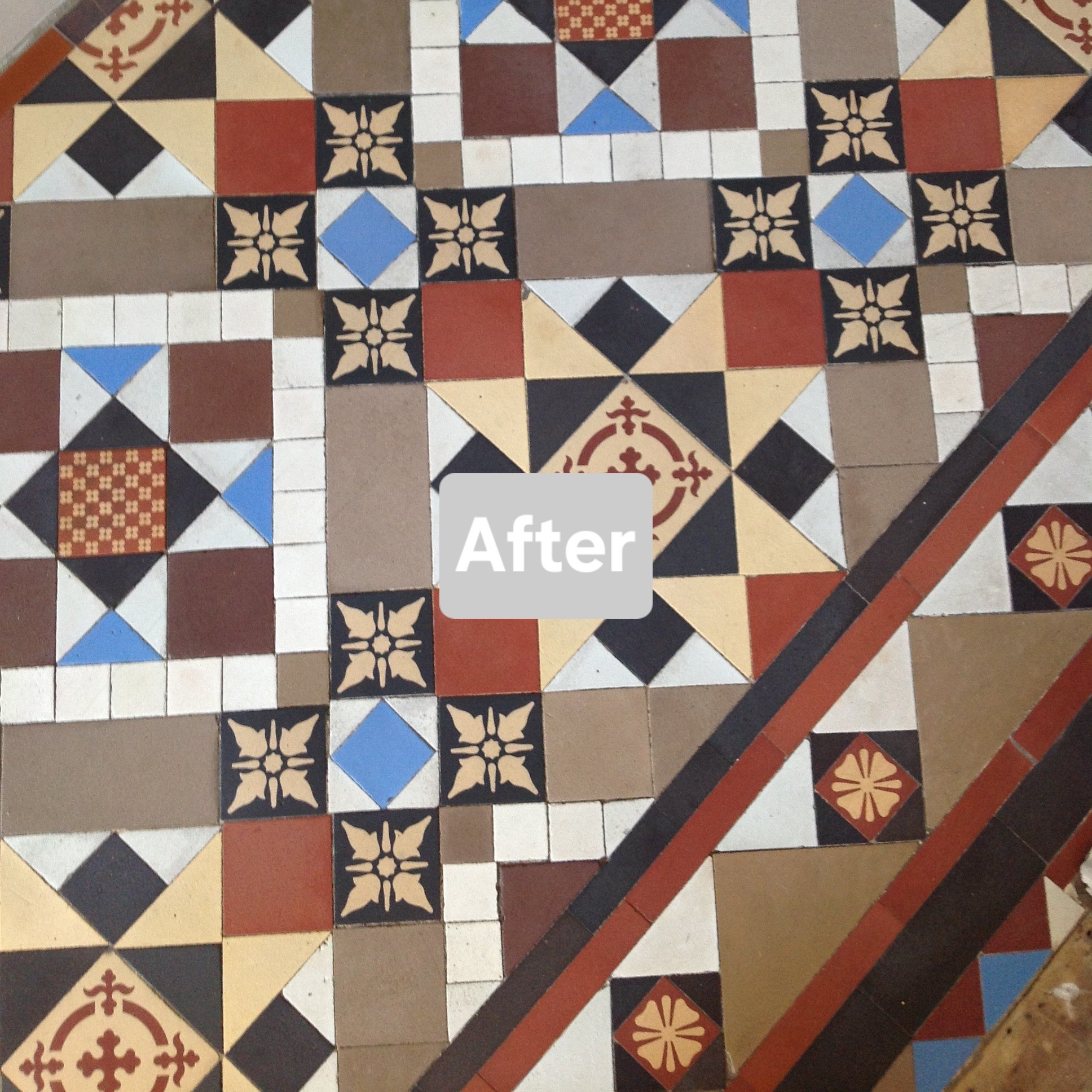 Colorful decorative tile floor with patterns including squares, diamonds, and floral motifs in black, white, blue, red, beige, and brown.