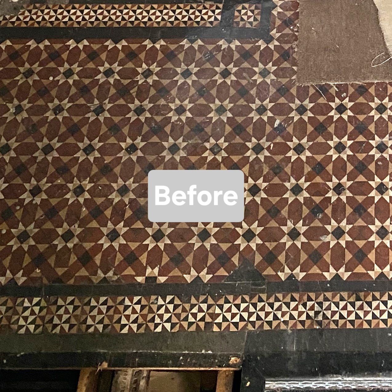 A patterned tile floor with geometric brown, beige, and black stars and triangles, some sections are damaged or missing tiles.