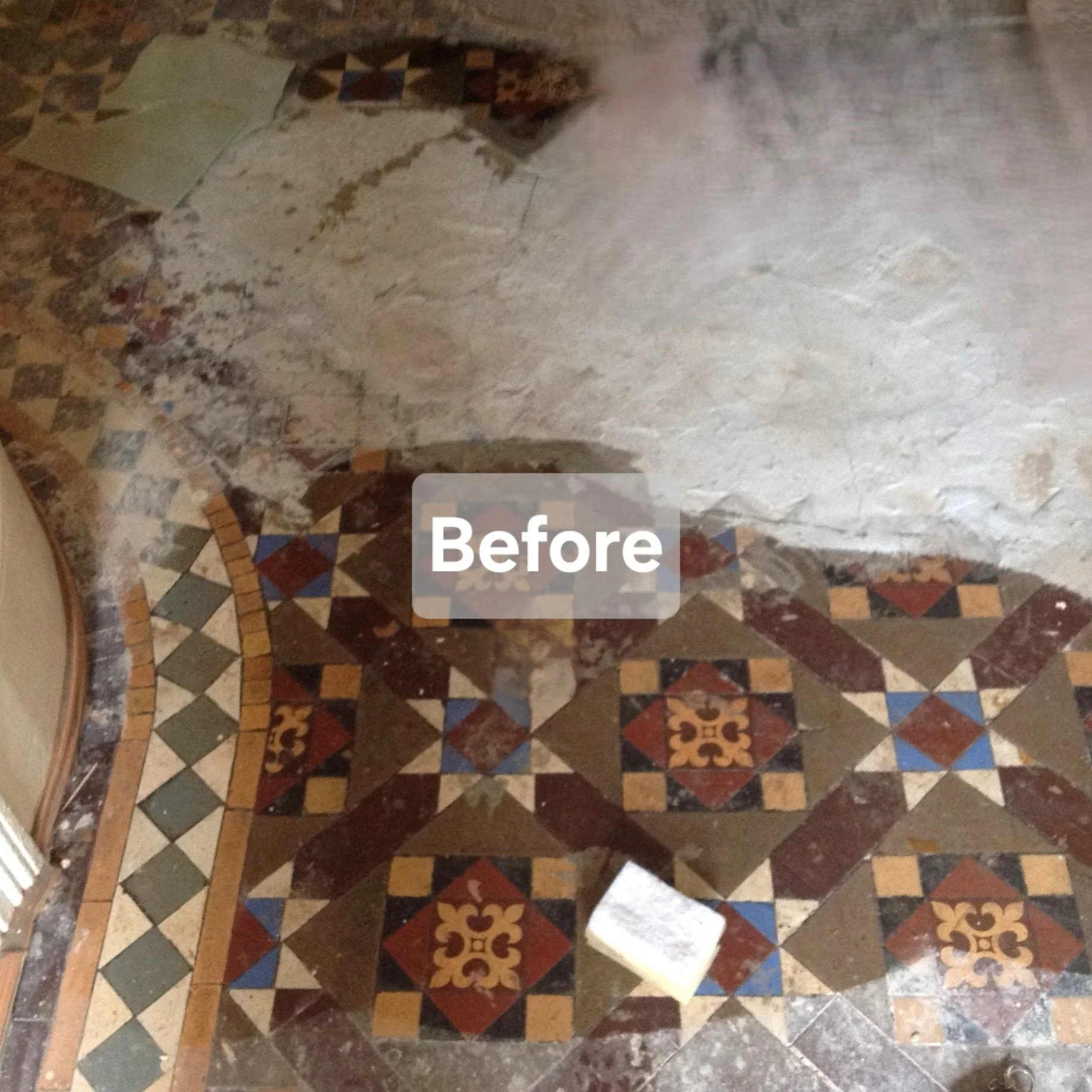 A mosaic tile floor with a decorative pattern in multiple colors, partially covered by a layer of white material and a small white object on the floor. The word 'Before' is written in white text in the center.