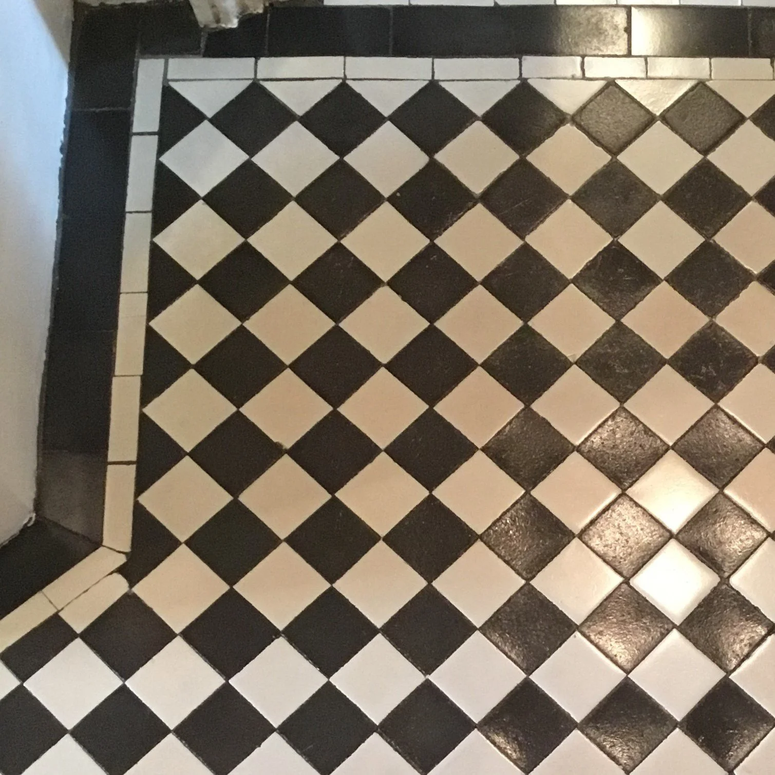 Black and white checkered tiled floor and wall.