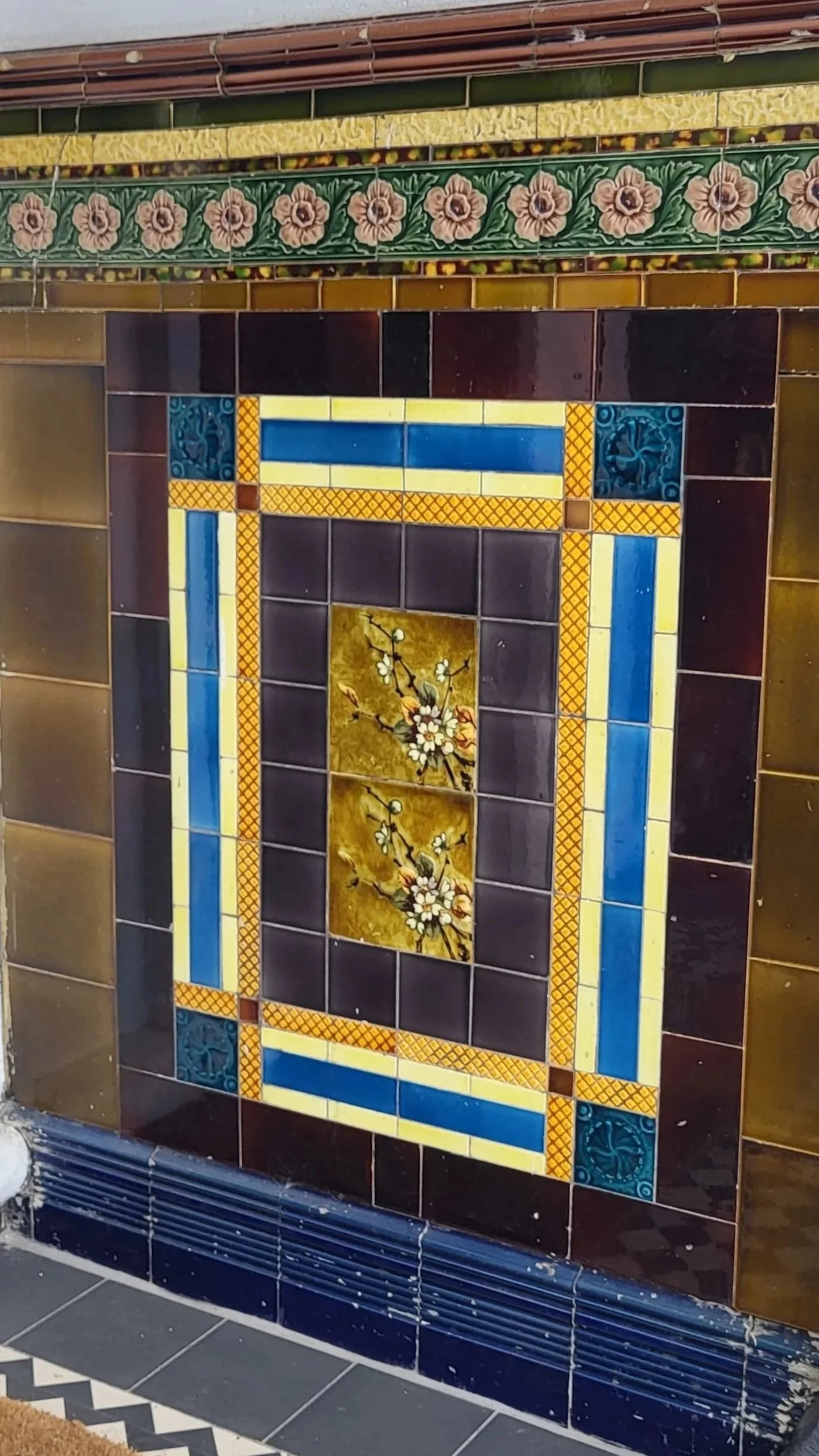 Decorative tiled dado panel with floral pattern and geometric design