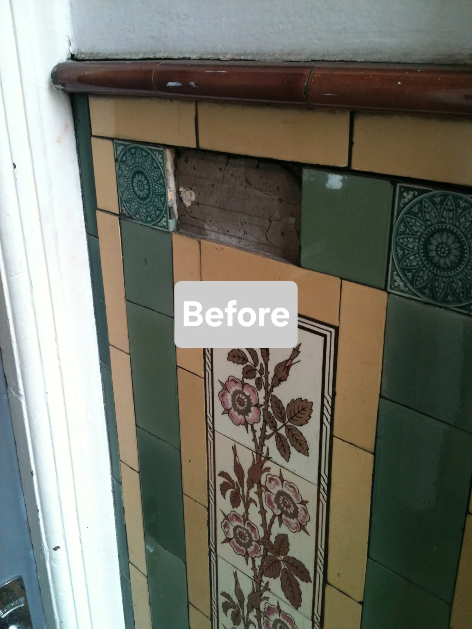 Tile wall with a gap revealing underlying brick and mortar, decorative green and beige tiles, and a wooden trim at the top.