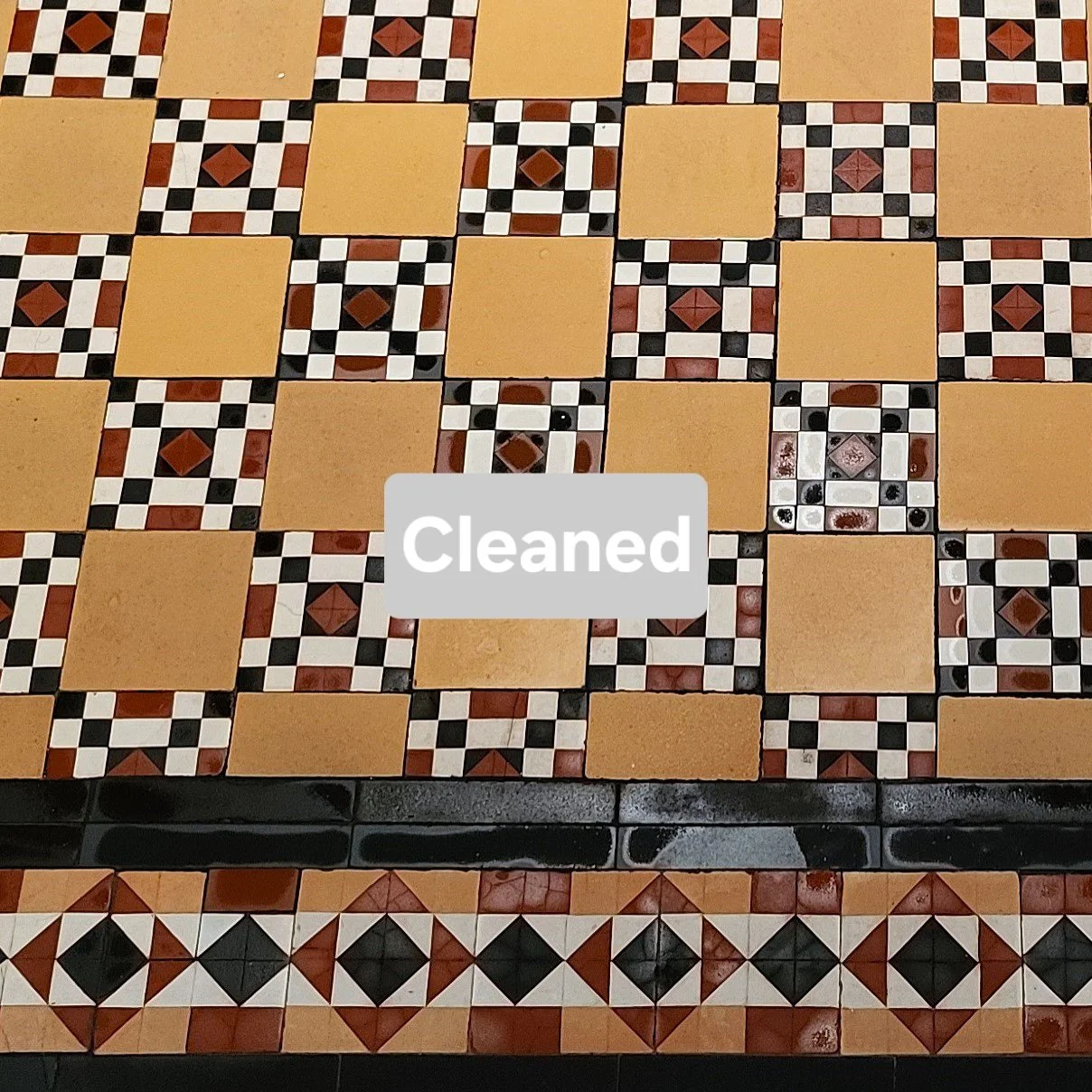 Cleaned mosaic tile floor with geometric pattern in black, white, beige, and reddish-brown colors.