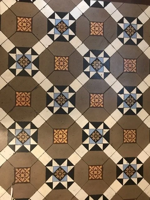 Patterned tile floor featuring the classic Victorian star motif and four hexagons framing an encaustic tile
